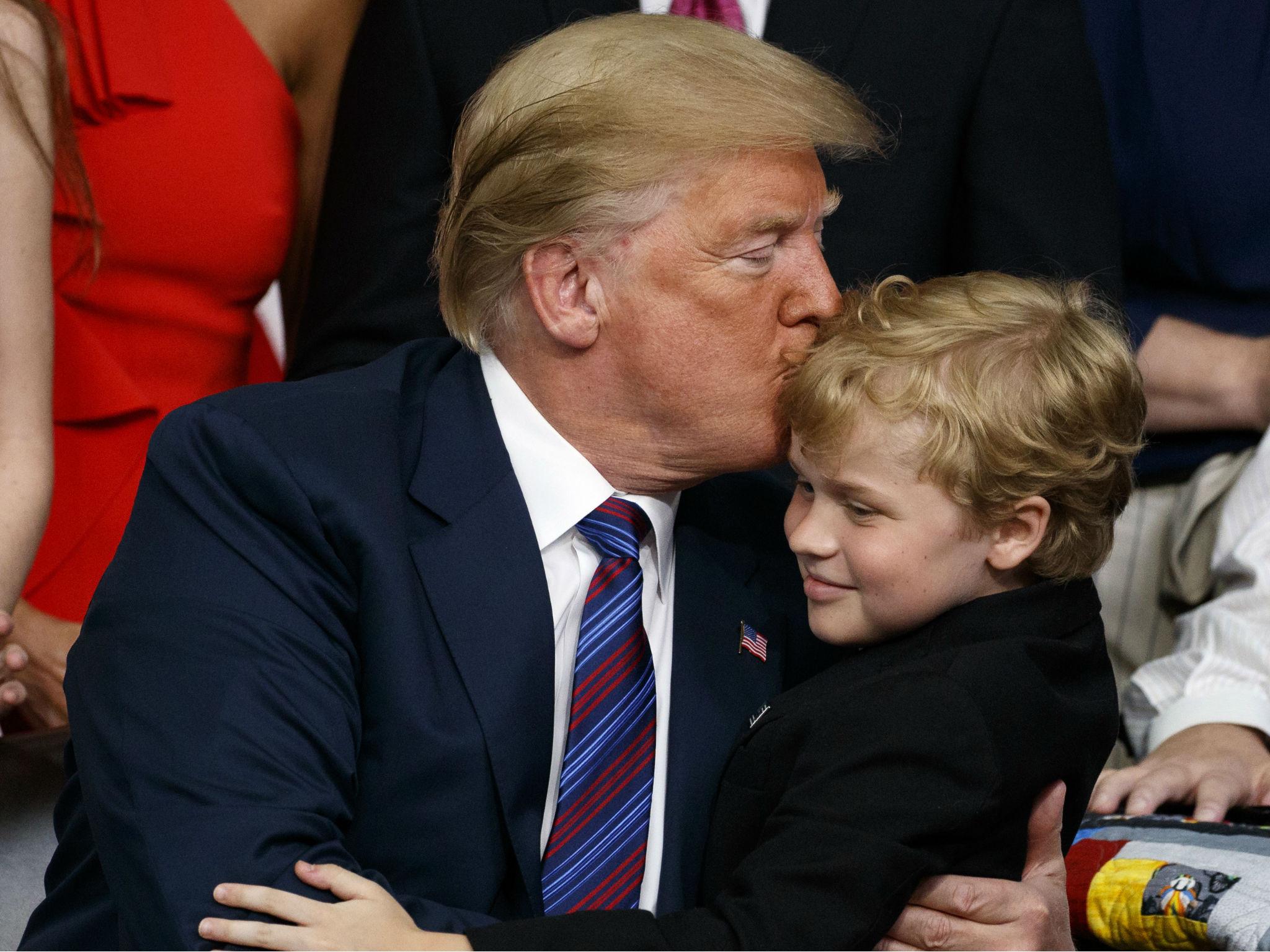 Mr Trump embraces a child with muscular dystrophy after signing the right to try law