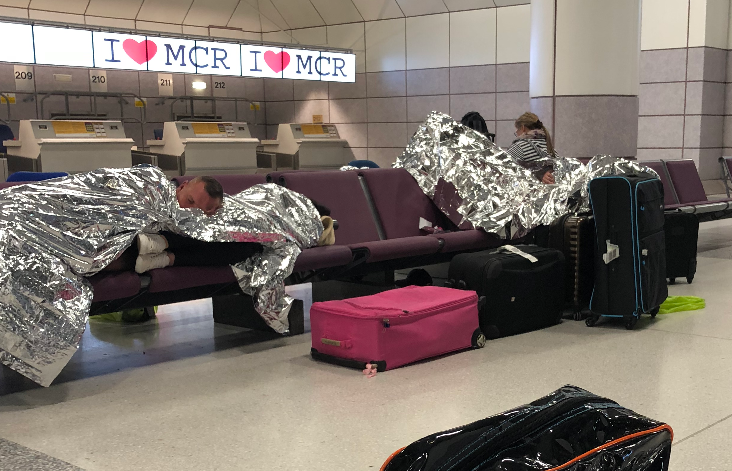 Passengers from a delayed TUI flight to Turkey spend the night at the check-in area of Manchester airport