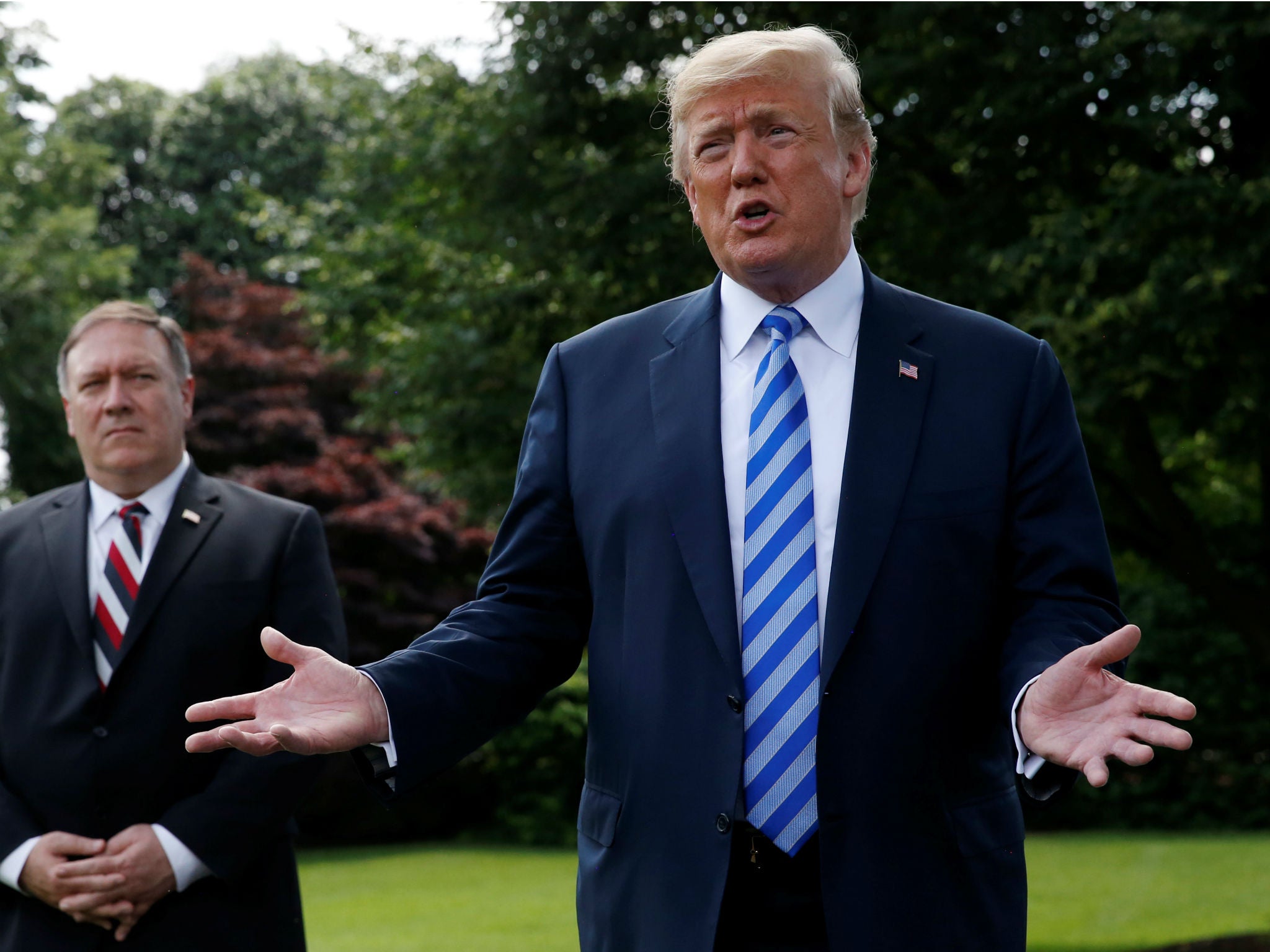 President Donald Trump talks with the media outside the White House as US Secretary of State Mike Pompeo looks on