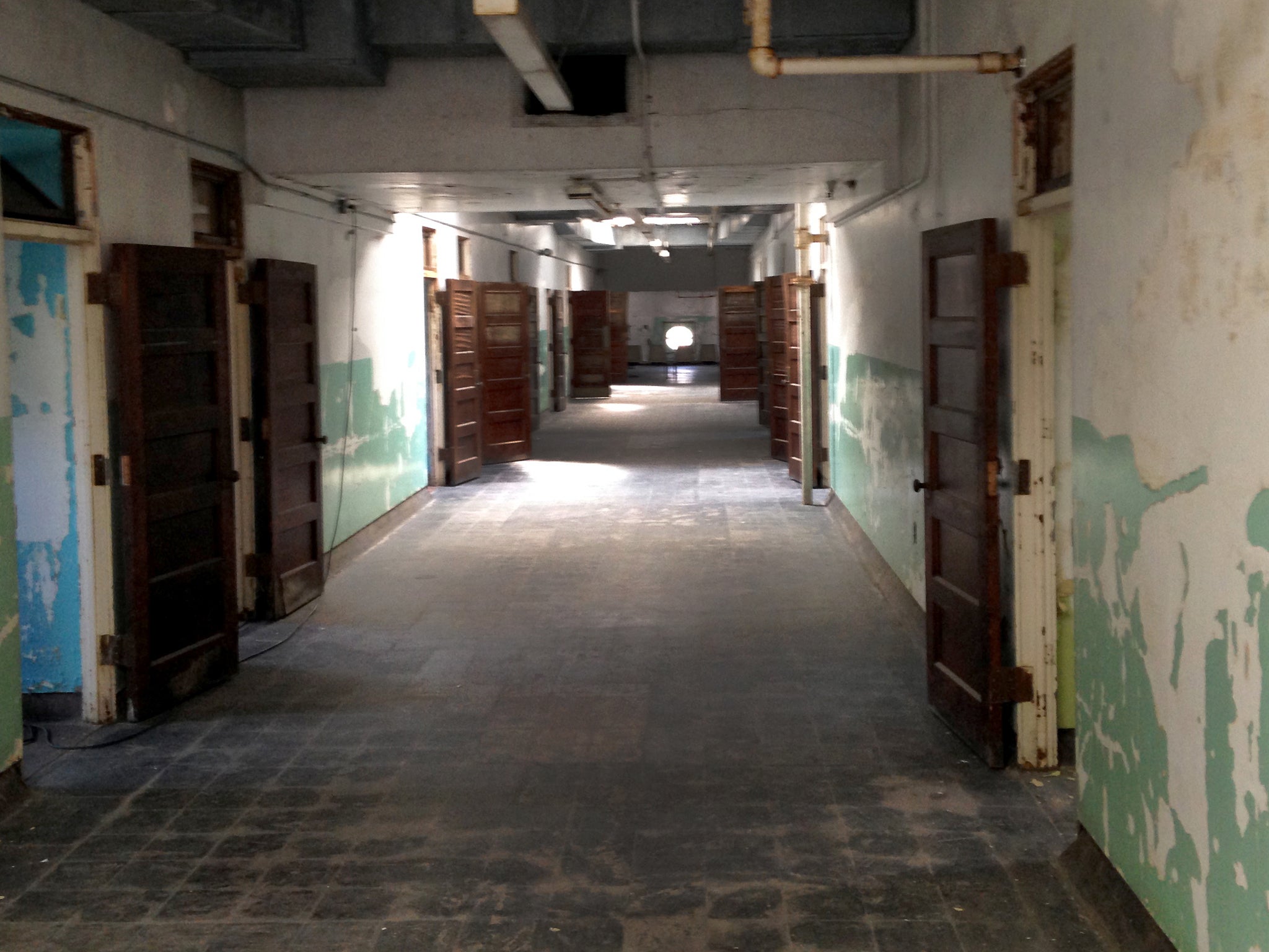 Many of the interior corridors are unrestored, with bare floors and peeling paint