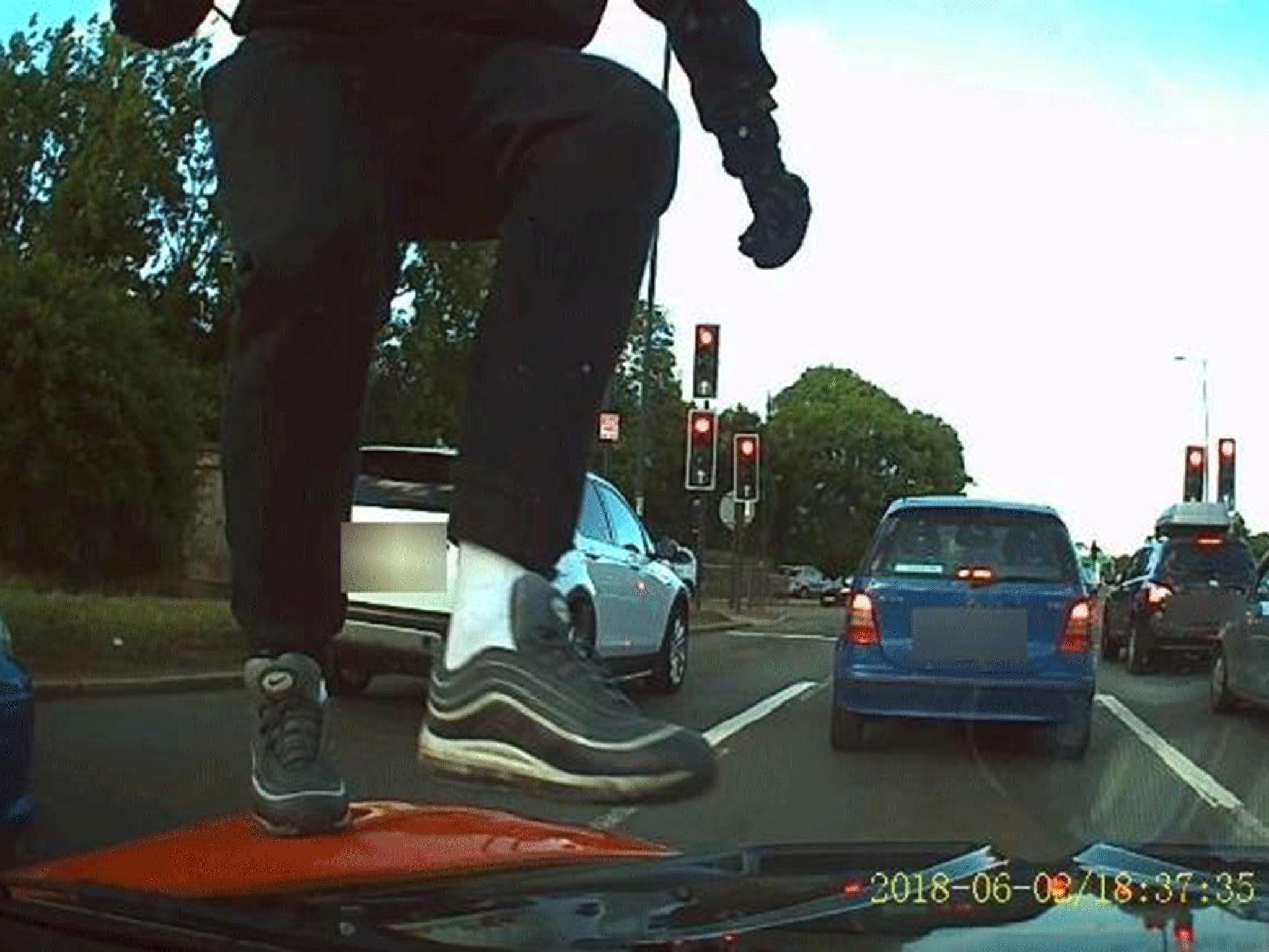 A moped robber armed with a knife attacking a car in London on 2 June