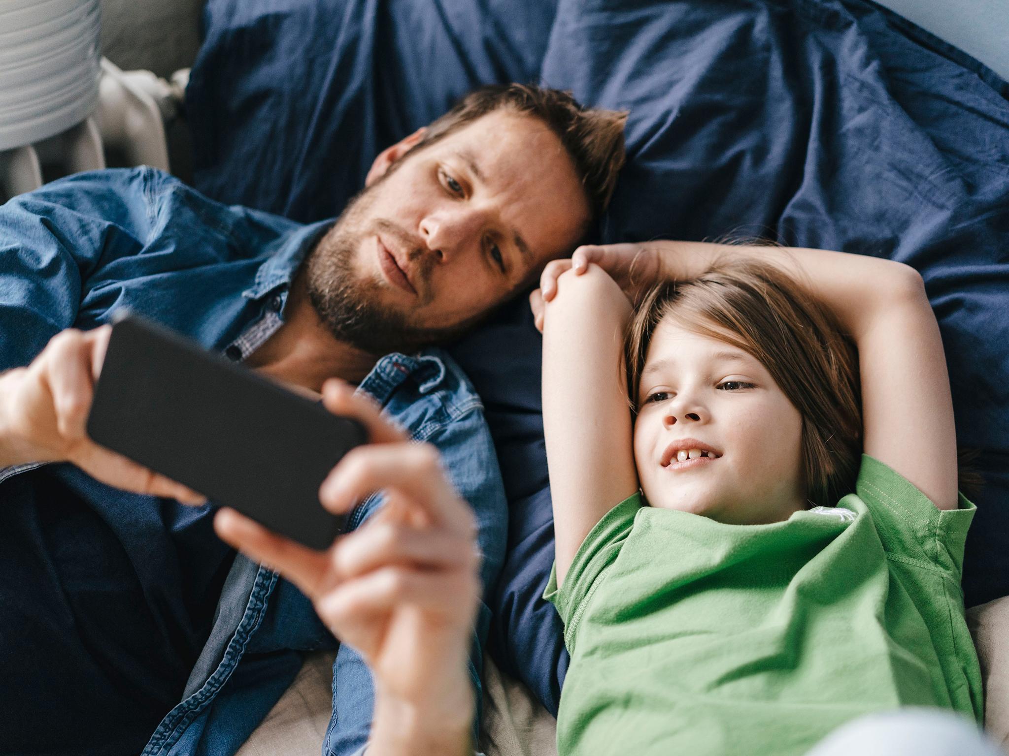 Father and son looking at smartphone together at home