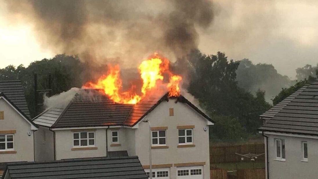 The roof of a detached house stands ablaze following a lightning strike. @impaulharper