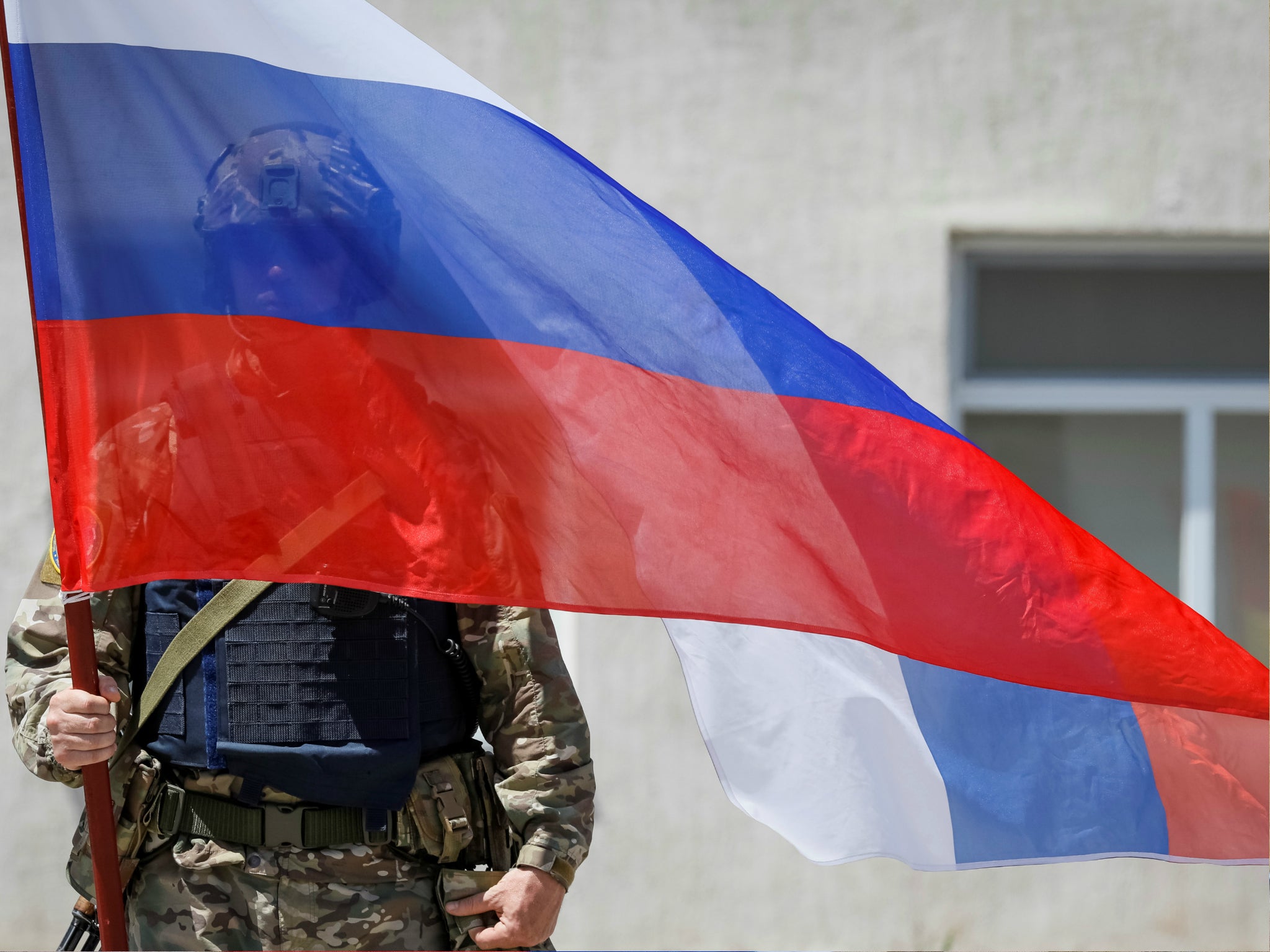 A member of Russia's special operations unit stands with a national flag. In June the US Treasury imposed sanctions on Russia for suspected cyber attacks.