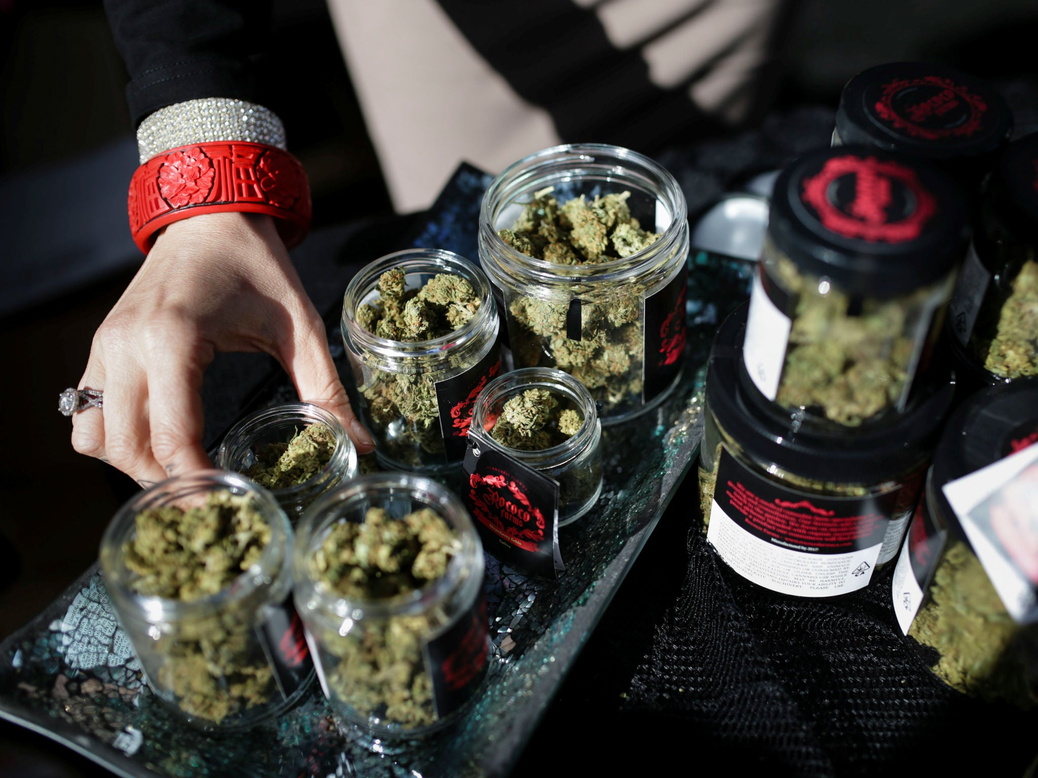 An employee puts down an eighth of marijuana after letting a customer smell it outside the Magnolia cannabis lounge in Oakland, California