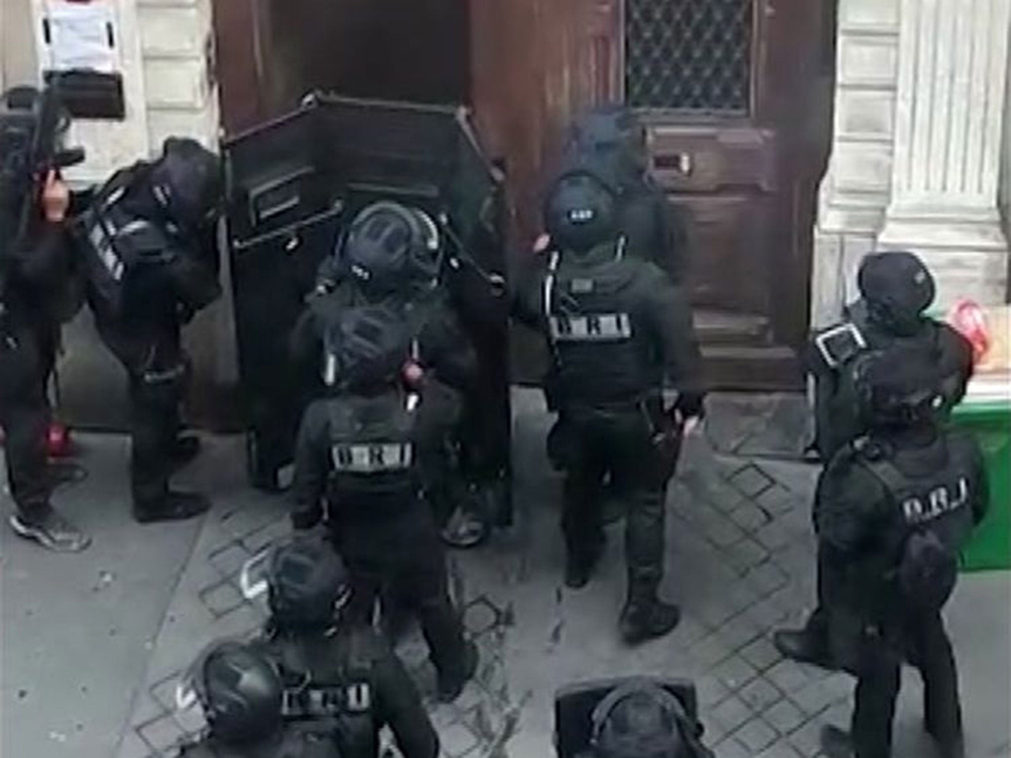 Police in riot gear surrounded the entrance of a building in central Paris where a man is believed to be holding two people hostage