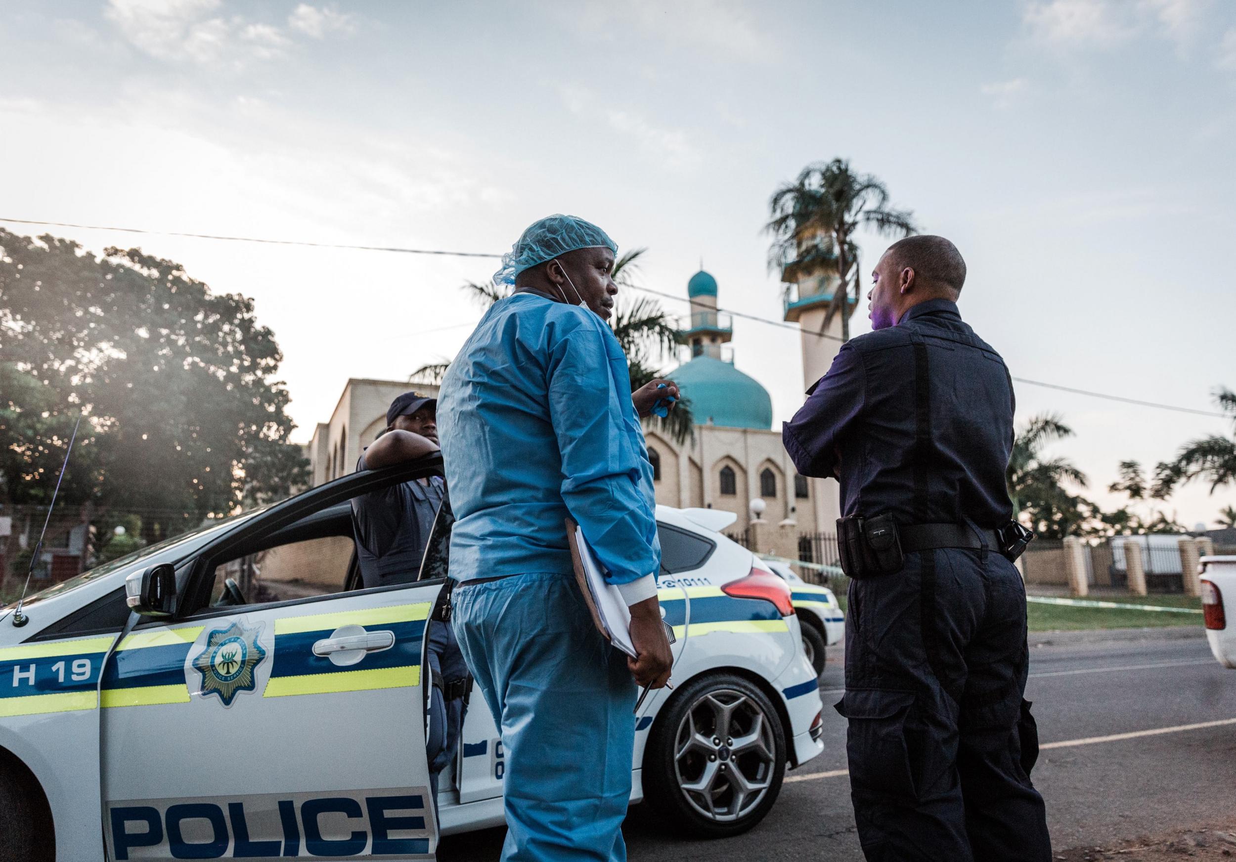 File image: Police investigators gather outside the entrance to a mosque outside Durban that was targeted in a separate attack in May