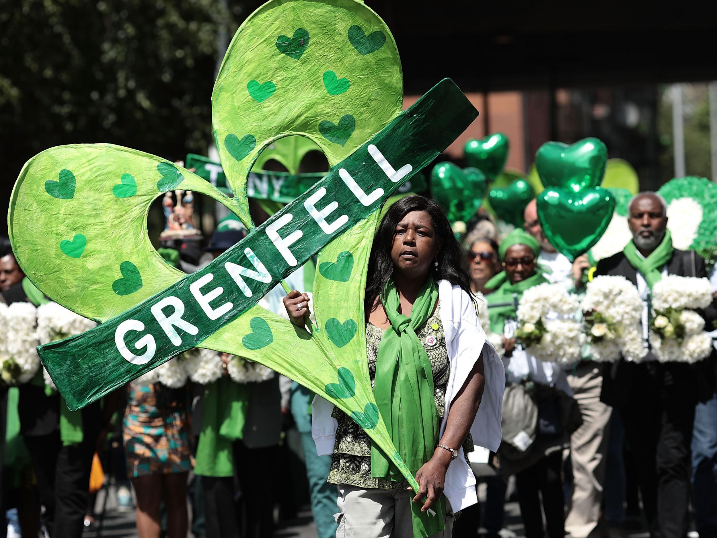 Clarrie Mendy leads a procession of mourners on the one year anniversary of the fire