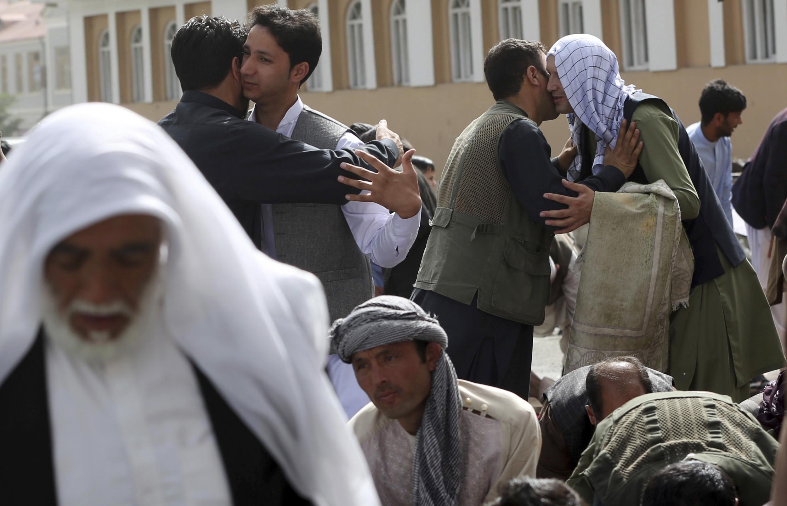 Men hug each other after Eid al-Fitr prayers outside of Shah-e-Dushamshera mosque in Kabul, Afghanistan on Friday (AP Photo/Massoud Hossaini)