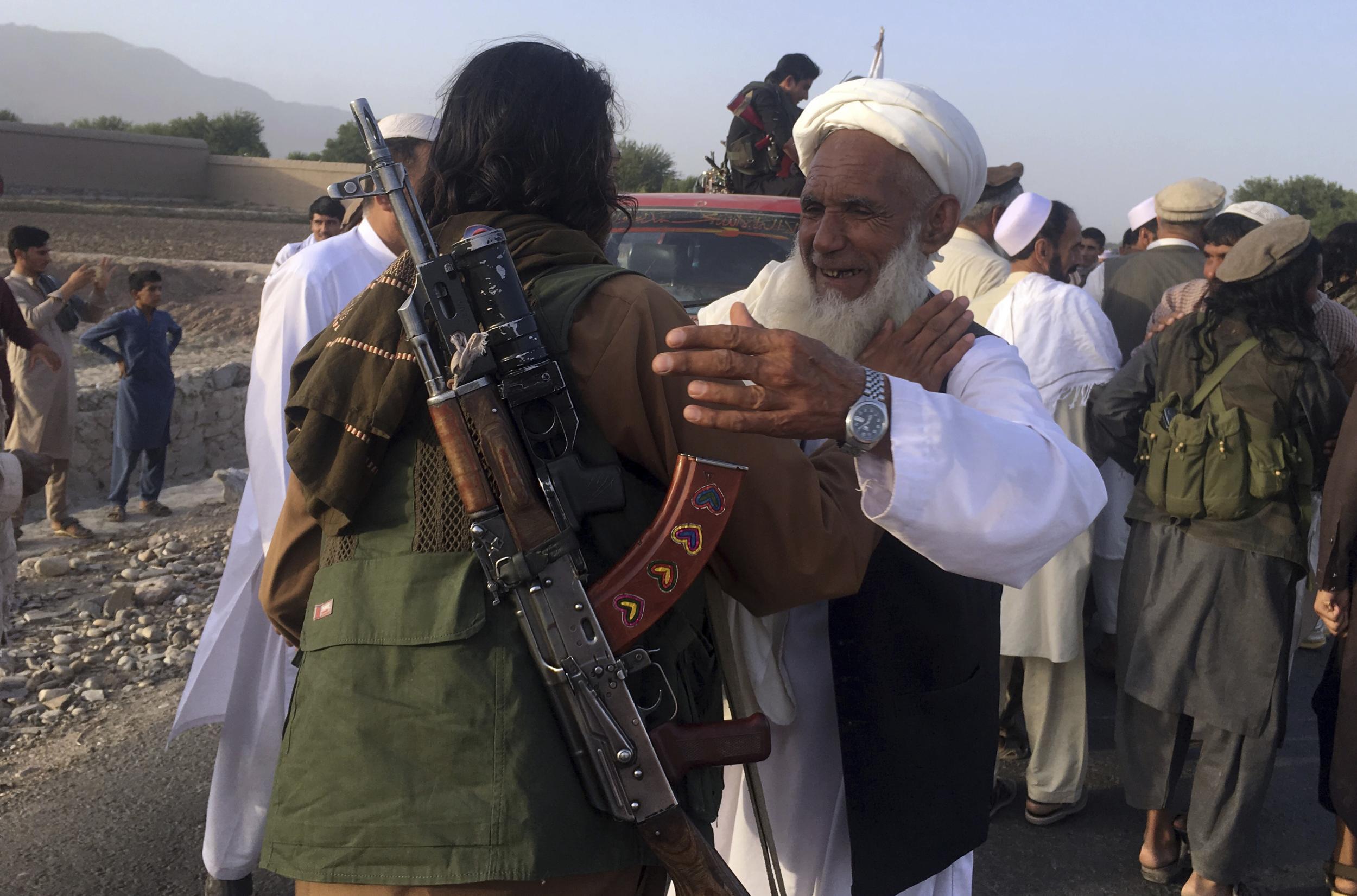 Taliban fighters gather with the residences in Surkhroad district of Nangarhar province, east of Kabul, Afghanistan, Saturday, June 16, 2018. A suicide bomber blew himself up in eastern Afghanistan on Saturday as mostly Taliban fighters gathered to celebrate a three-day cease fire marking the Islamic holiday of Eid al-Fitr, killing 21 people and wounding another 41, said the Nangarhar provincial Police Chief Ghulam Sanayee Stanikzai. Most of the dead and wounded were believed to be Taliban, he said. (AP Photo/Rahmat Gal)