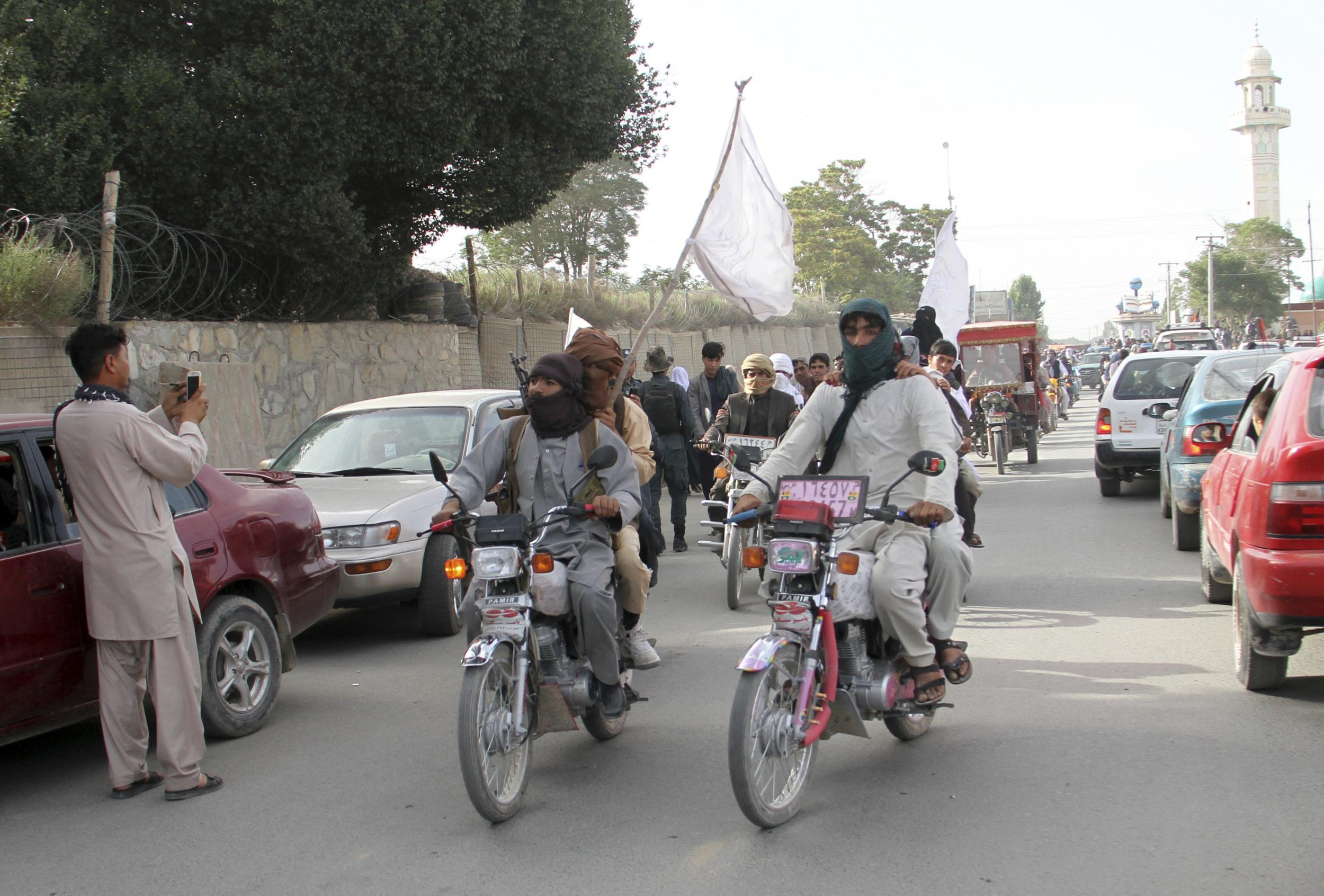 Taliban fighters ride their motorbikes inside Ghazni city (AP Photo)