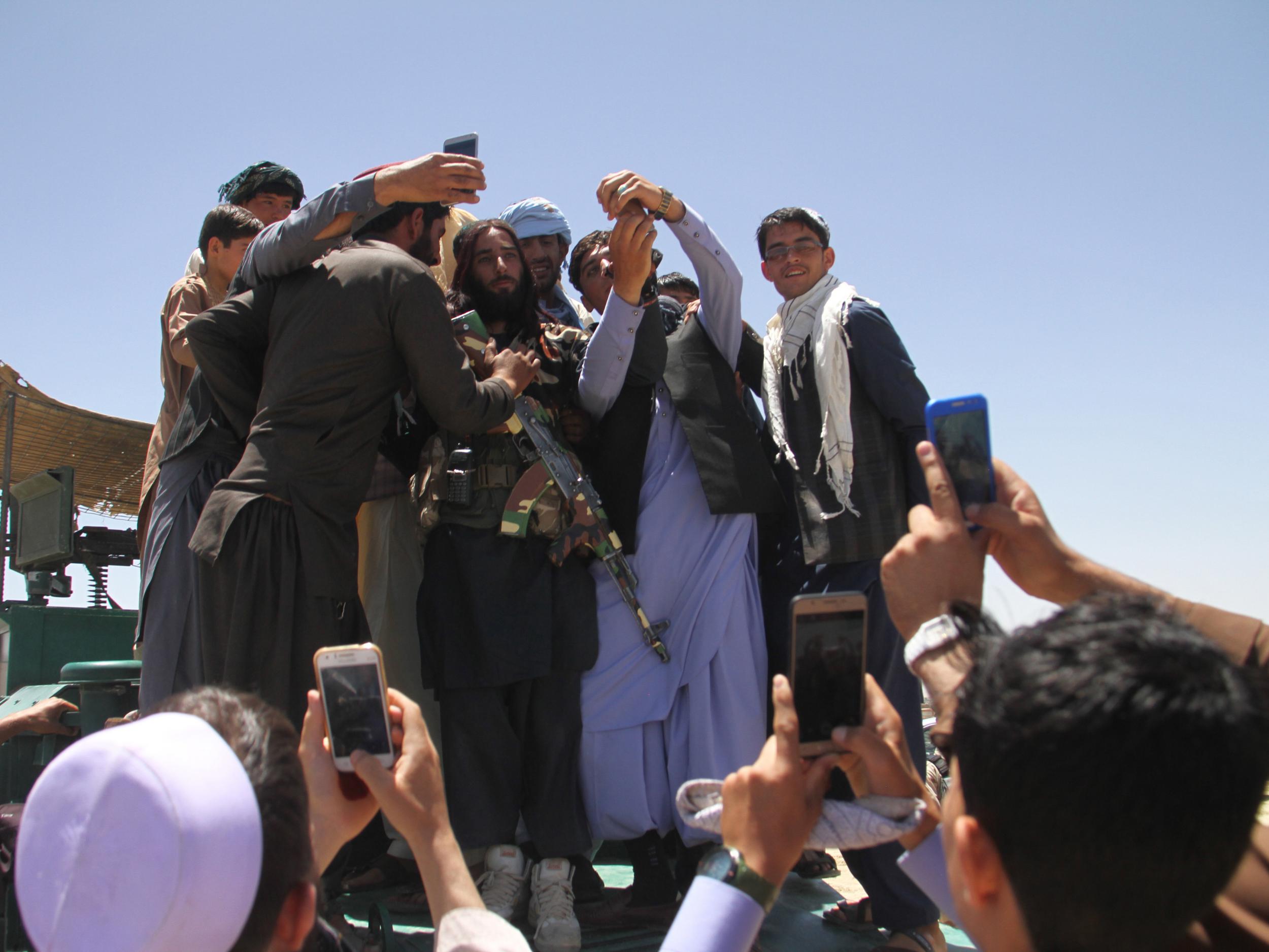 Taliban militants meets Afghan people during a visit to Ghazni on the on second day of a three-day ceasefire to mark Eid al-Fitr