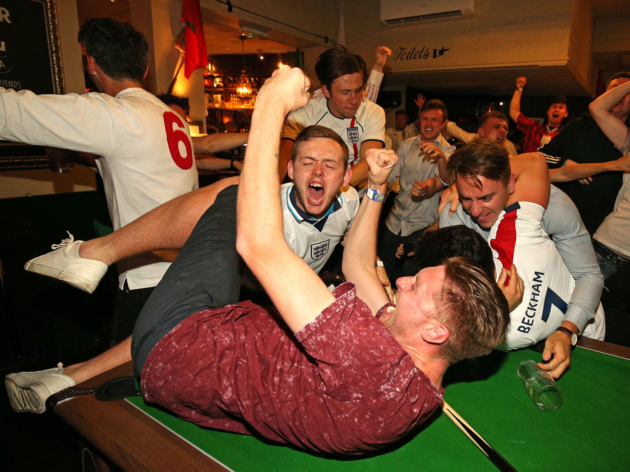 England supporters celebrate Harry Kane’s winning goal at the Lord Raglan Pub in London as fans watch the World Cup match between Tunisia and England in 2018