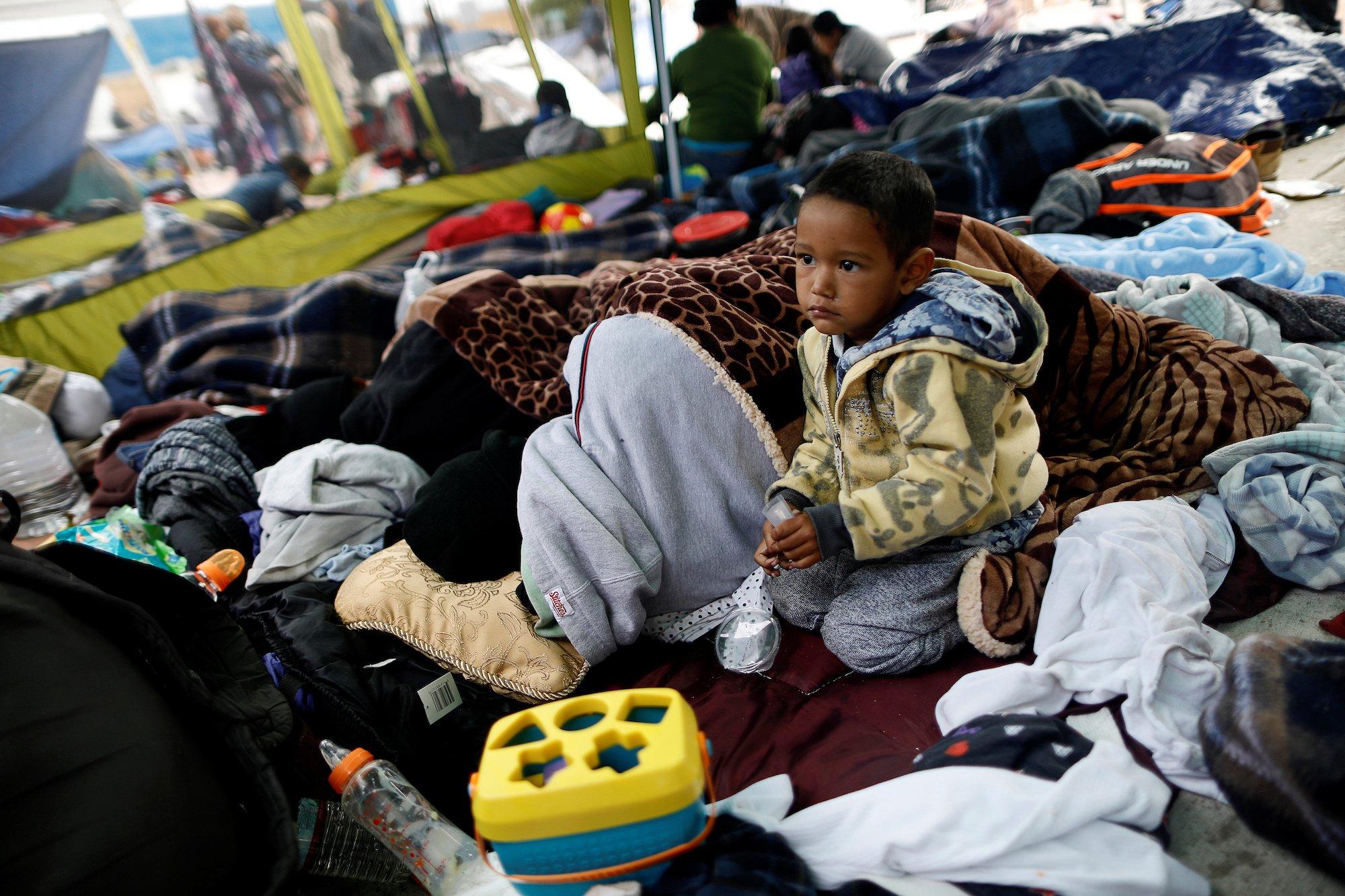 A child traveling with a caravan of migrants from Central America sits at a camp near the San Ysidro checkpoint