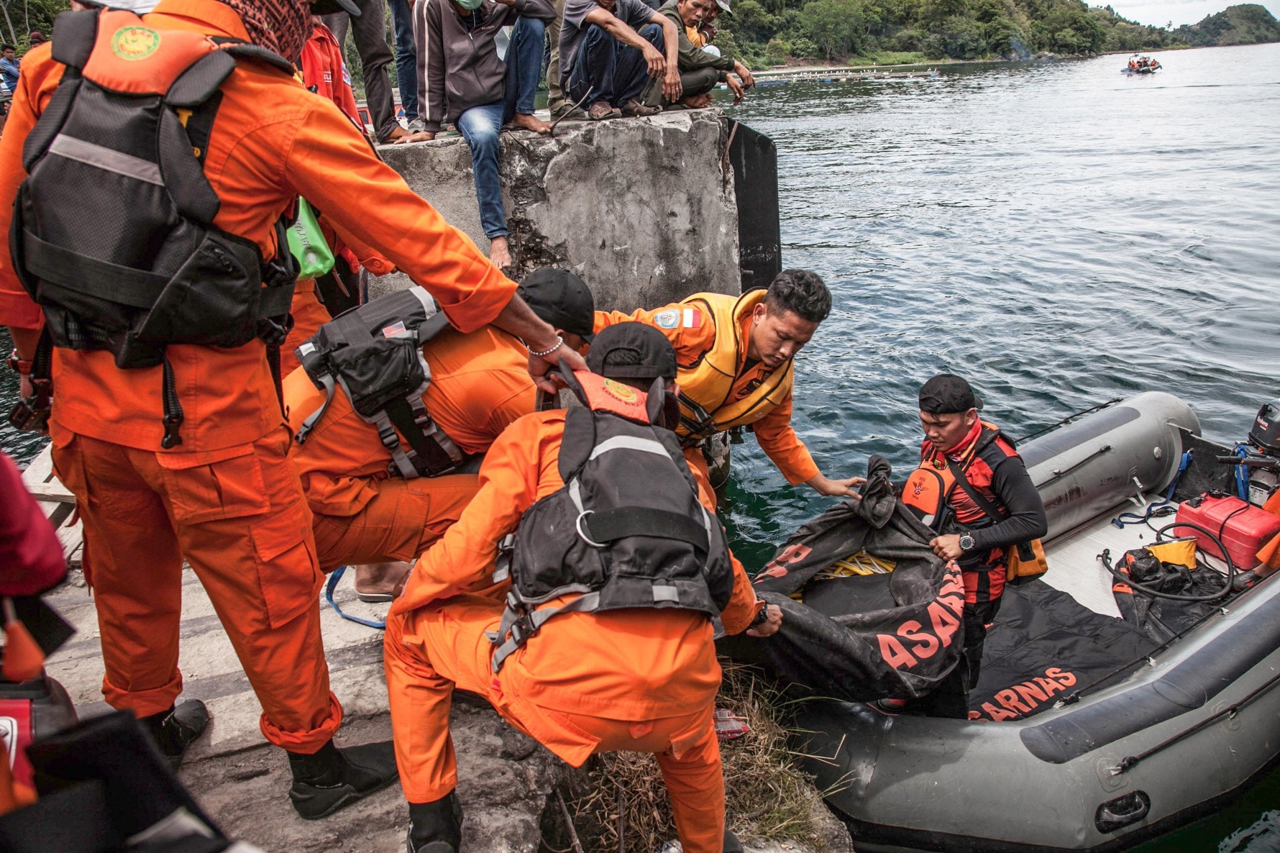 Rescue team members prepare to search for missing passengers at the Lake Toba ferry port on Wednesday