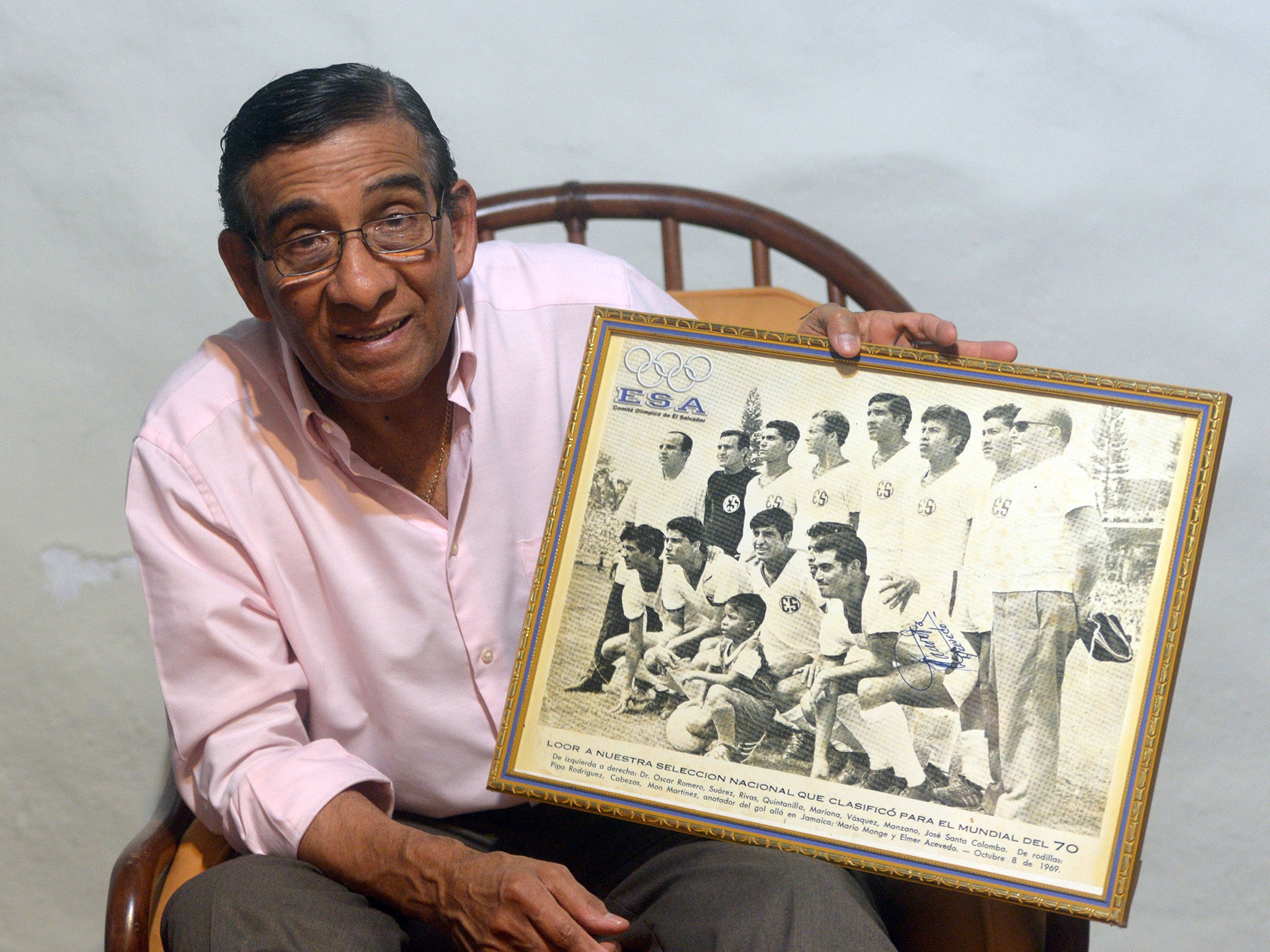 Former Salvadoran footballer shows a picture of the national team during the World Cup Mexico 1970