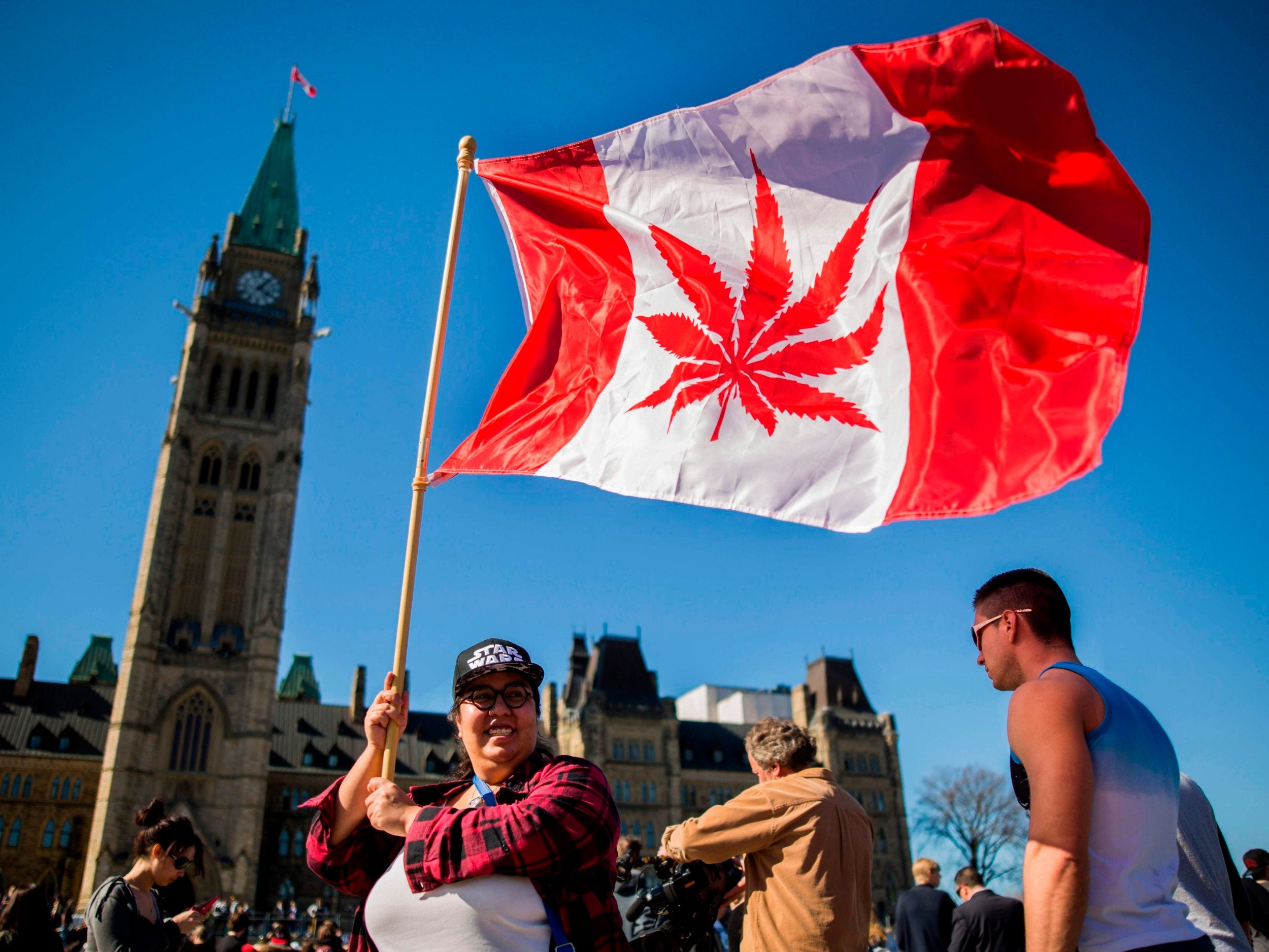 A campaigner waves a flag at a National Marijuana Day gathering in 2016 on Parliament Hill in Ottawa, Canada