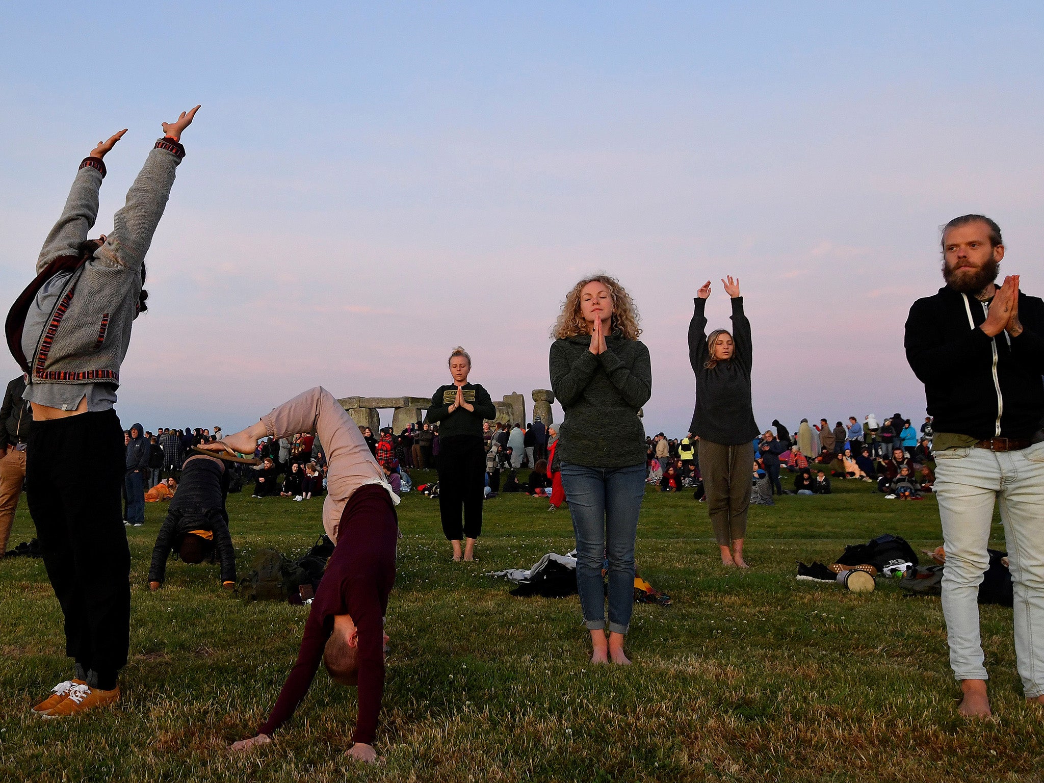 Some people practice yoga before sunrise as they welcome in the summer solstice at Stonehenge on 21 June 2018