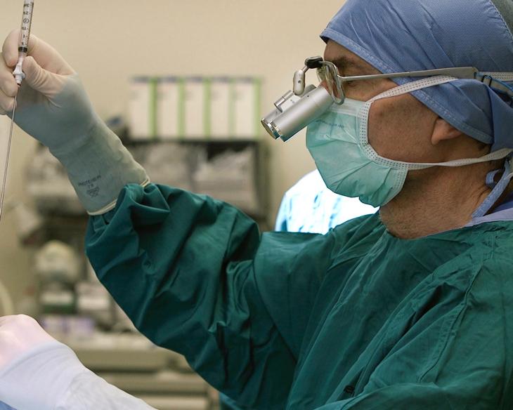 One of the study authors, Dr Alan Friedman performing neurosurgery to implant the catheter that will feed polio directly into the tumour