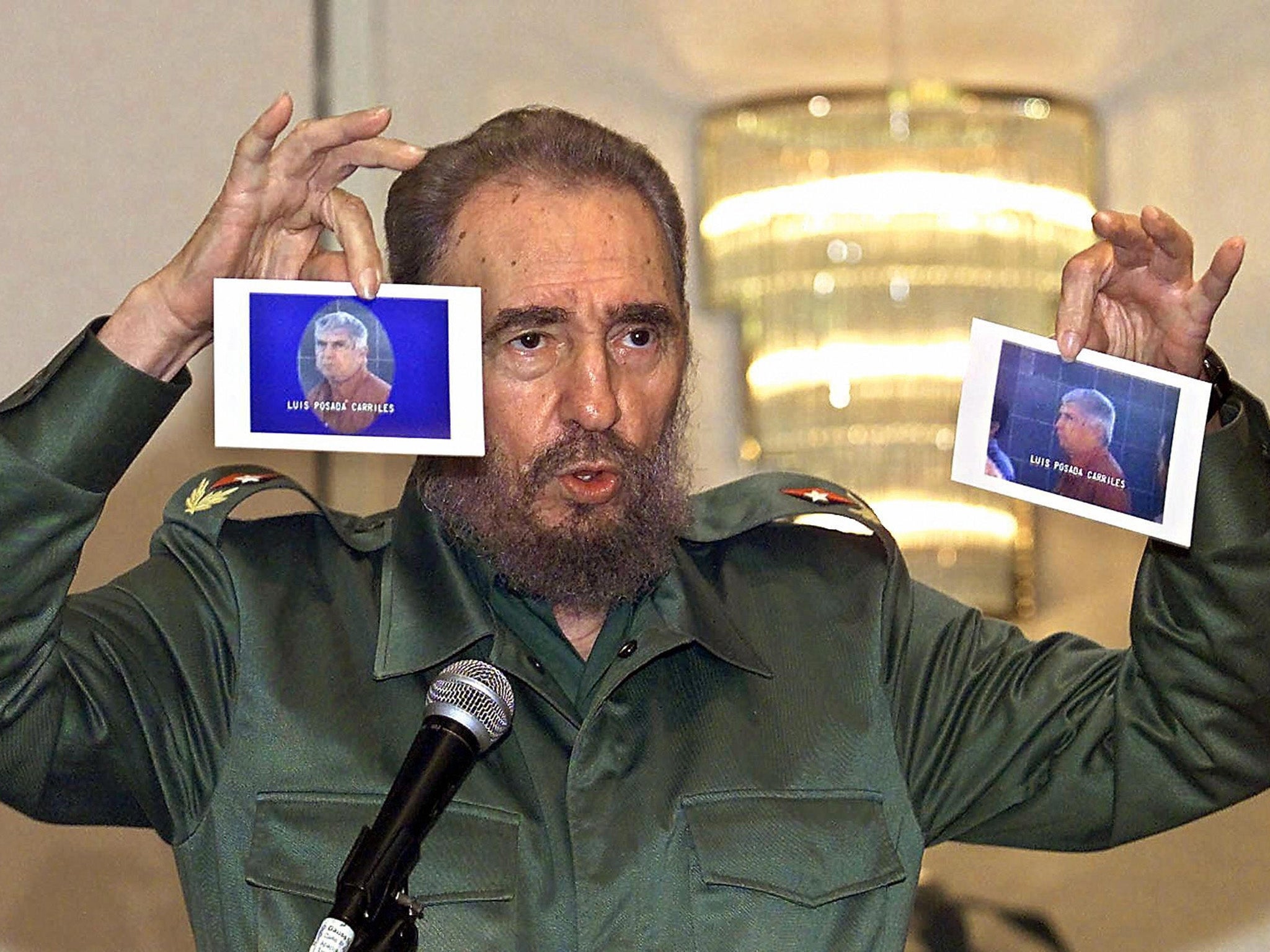 Fidel Castro holds up photos of Carriles at a press conference in Panama City in 2000