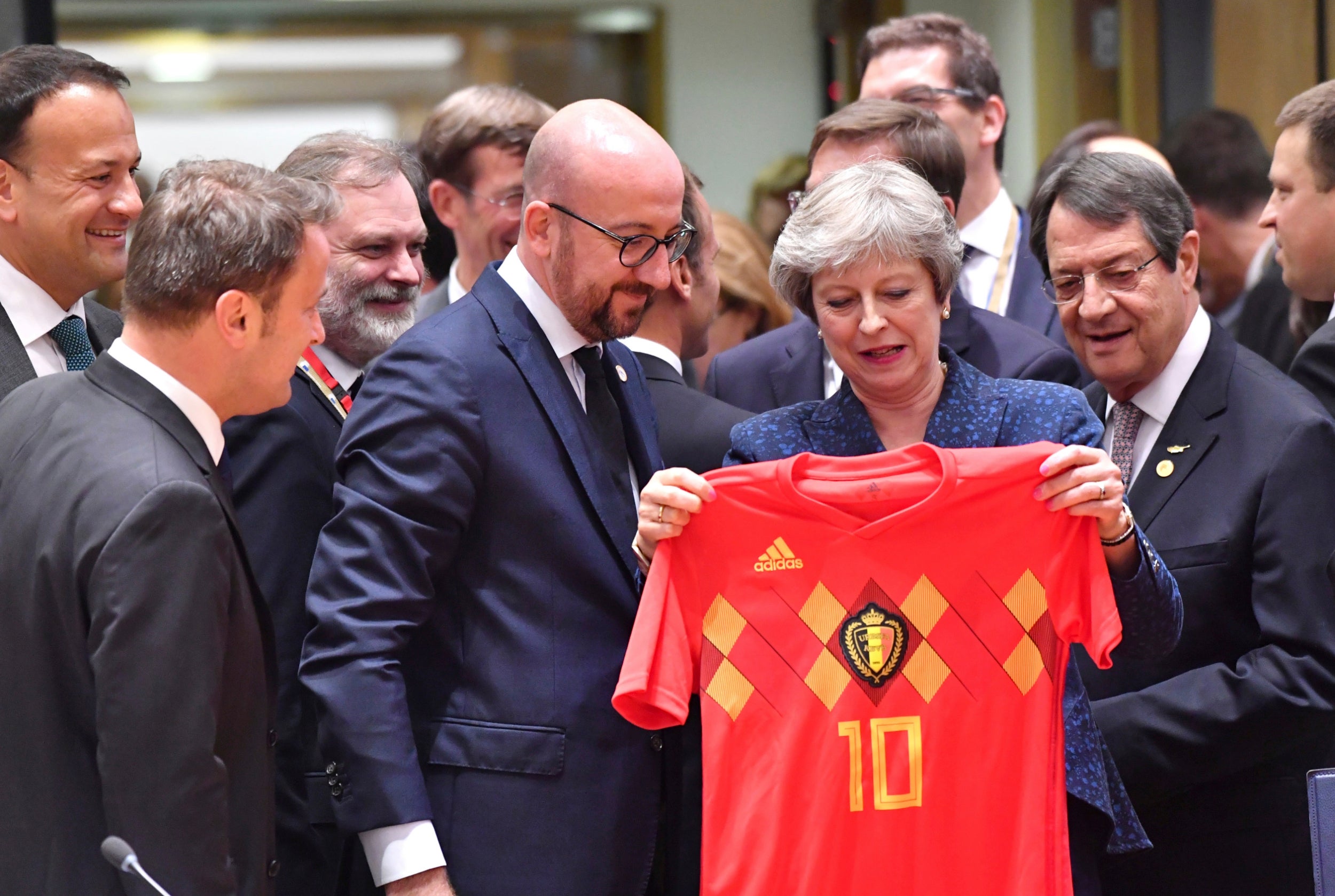 Theresa May is presented with a Belgian football shirt by Charles Michel, the Belgian prime minister, at the European Council in Brussels