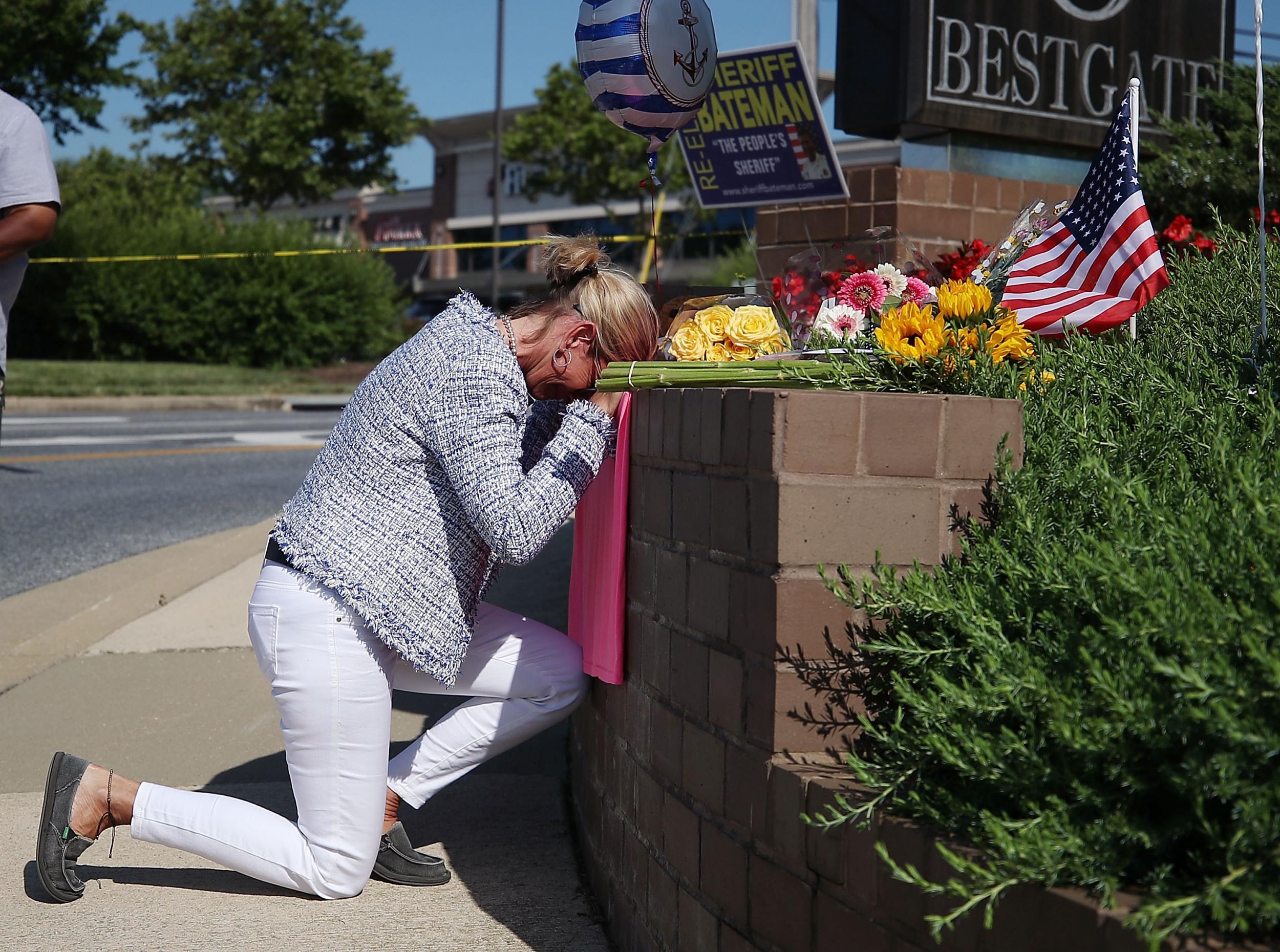 Lynne Griffin pays her respects at a makeshift memorial near the Capital Gazette where 5 people were shot and killed by a gunman on Thursday