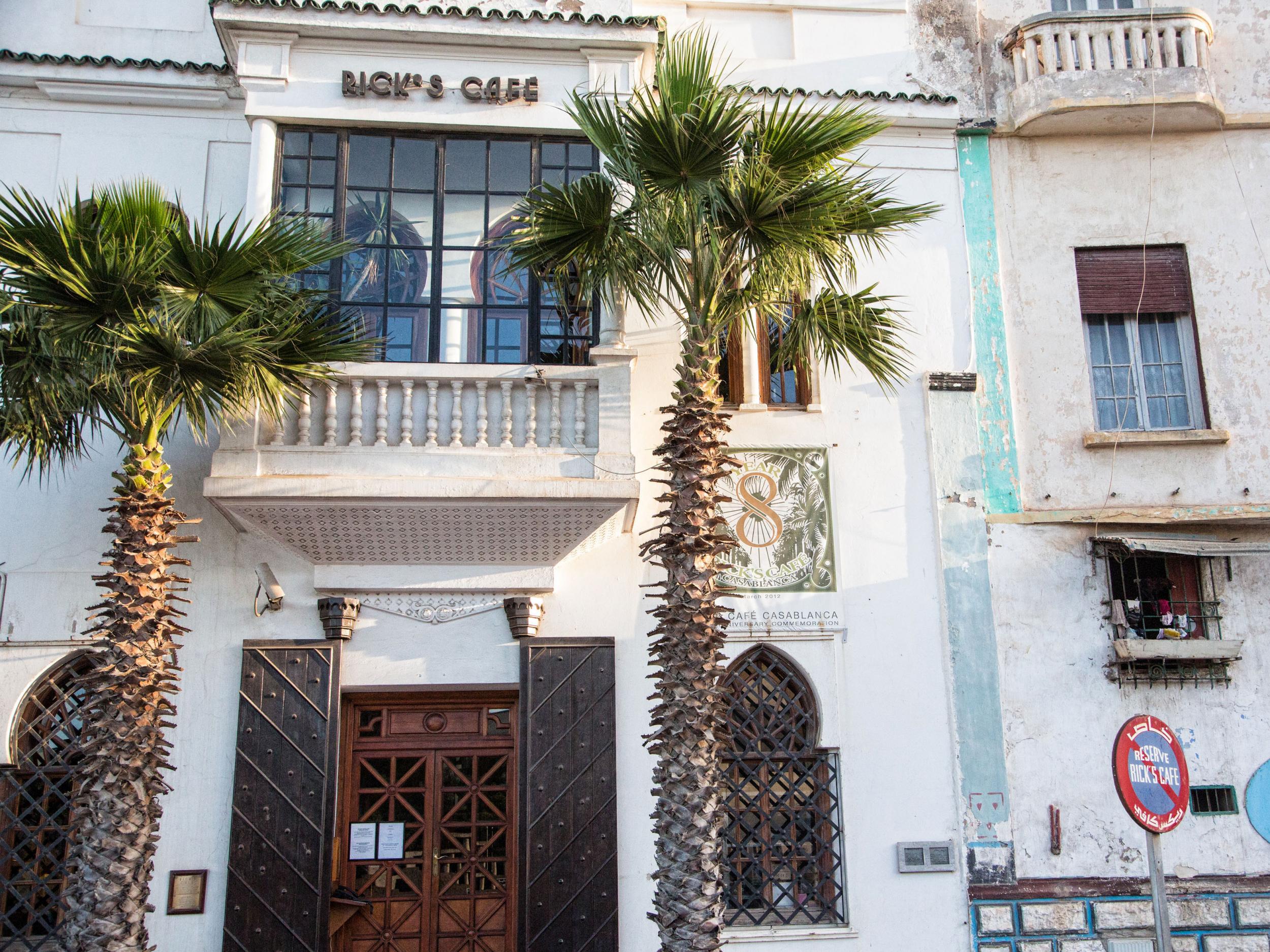 The entrance of Rick’s Café, with two royal palm trees flanking the front door