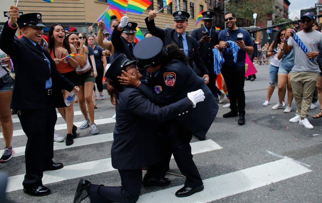 Members of the New York City Fire Department cheer as EMT Trudy Bermudez and paramedic Tayreen Bonilla get engaged at the annual Pride Parade on June 24, 2018 in New York City