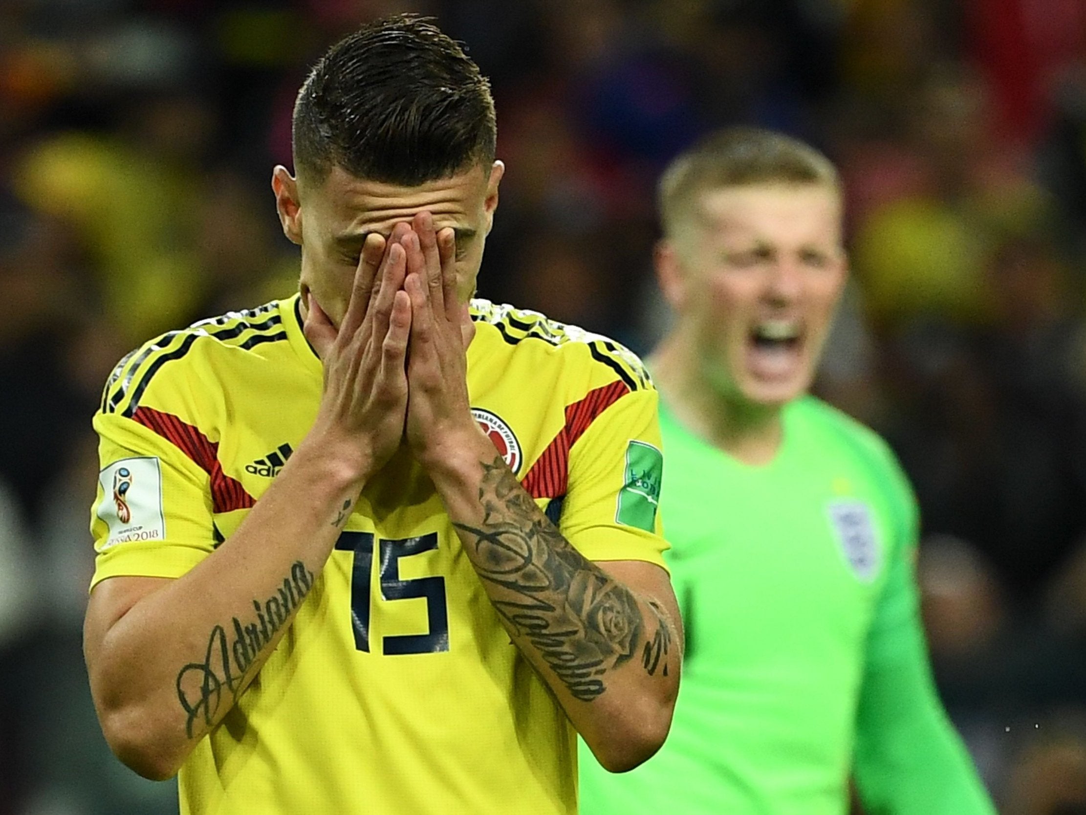 Mateus Uribe reacts after missing to score a penalty kick next to England's goalkeeper Jordan Pickford