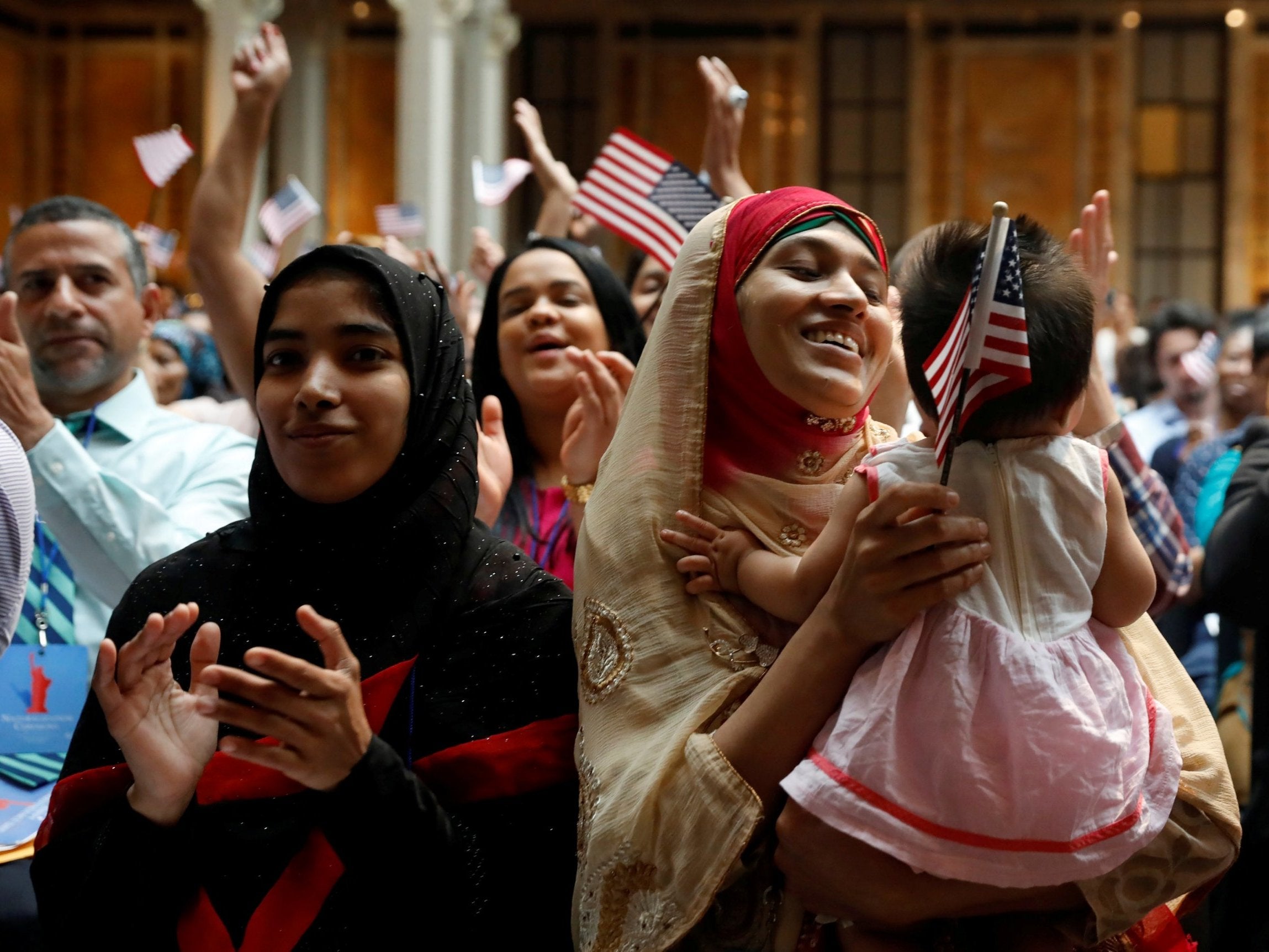 New US citizens smiling after becoming citizens during a ceremony at the New York Public Library on 3 July