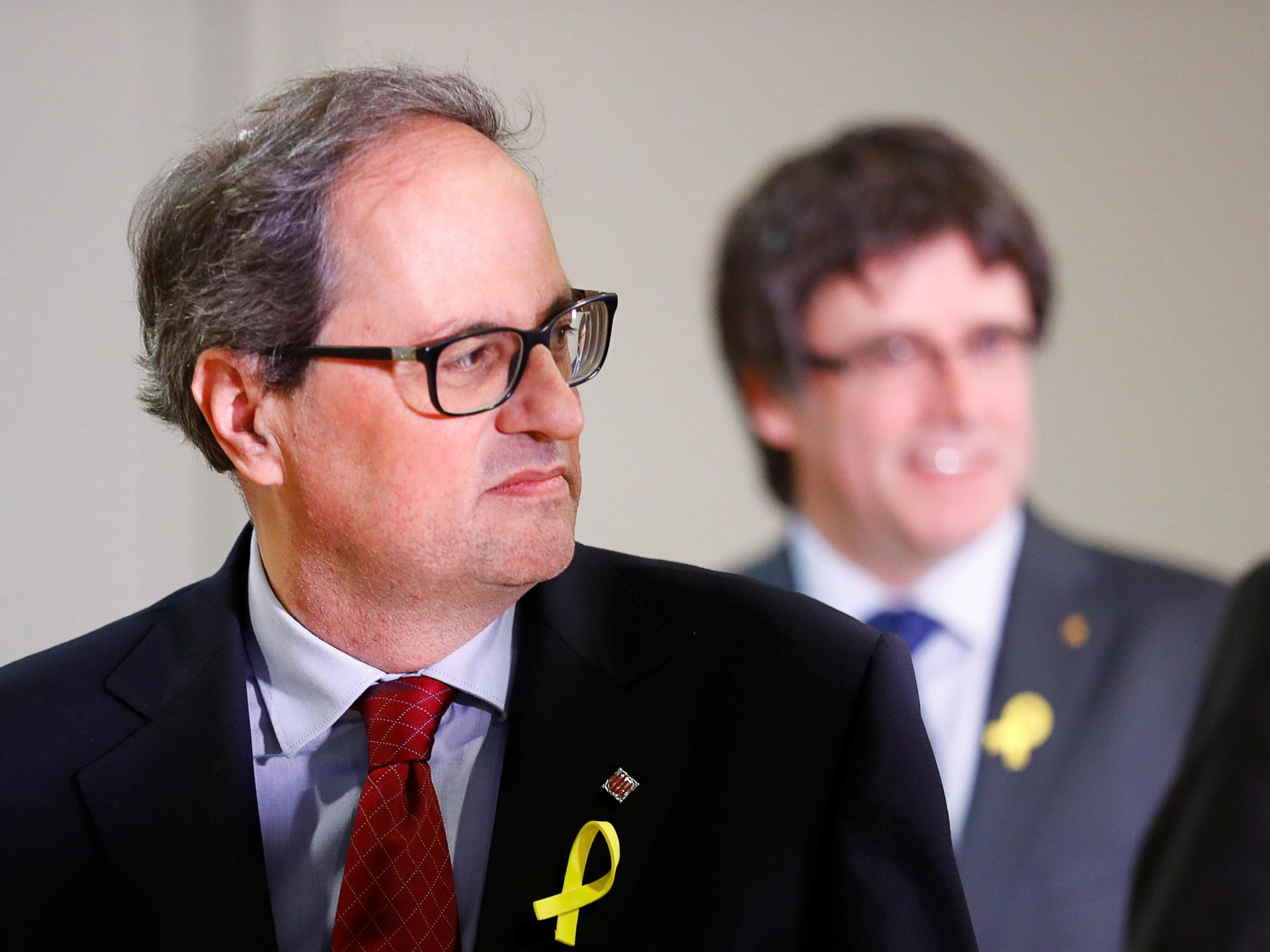 Regional leader of Catalonia Quim Torra (left) and his predecessor Carles Puigdemont (right) attend