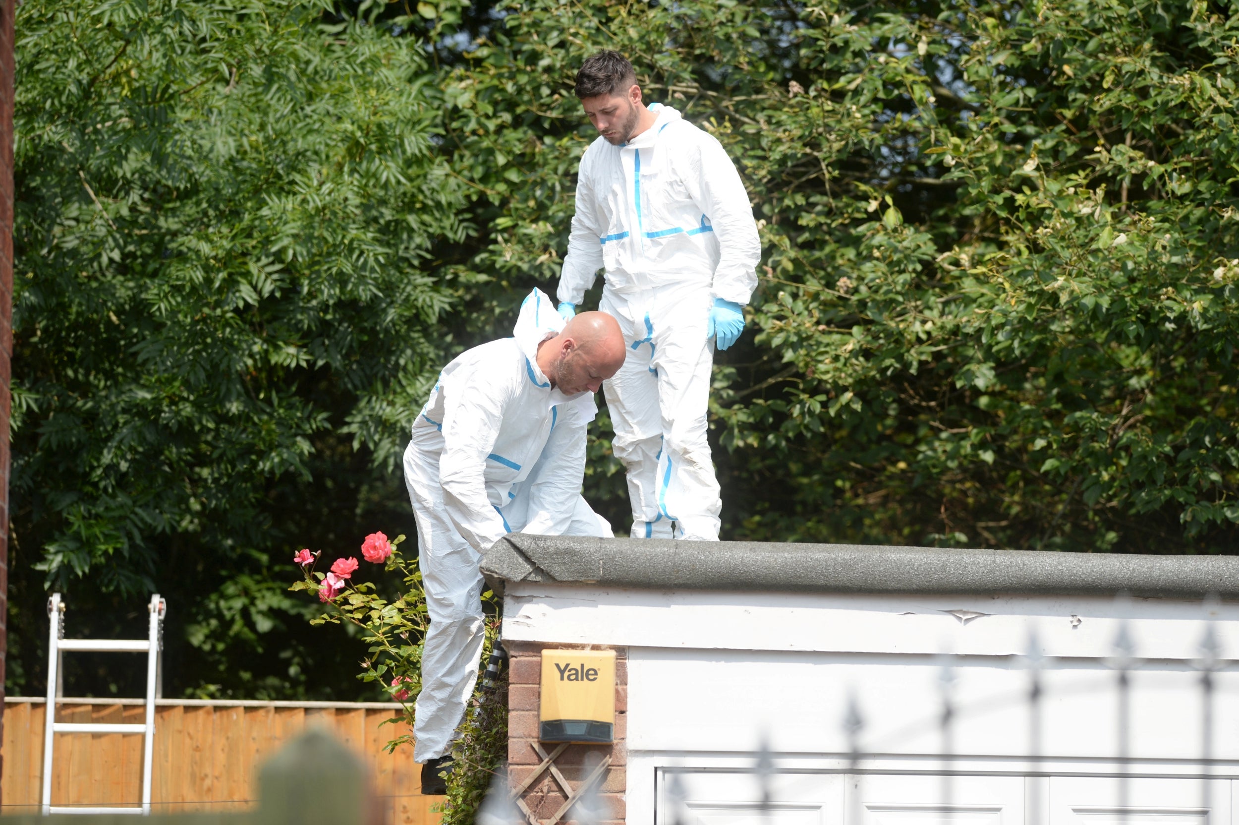 Forensics investigators on the roof of a neighbour’s garage adjoining the garden of nurse Lucy Letby