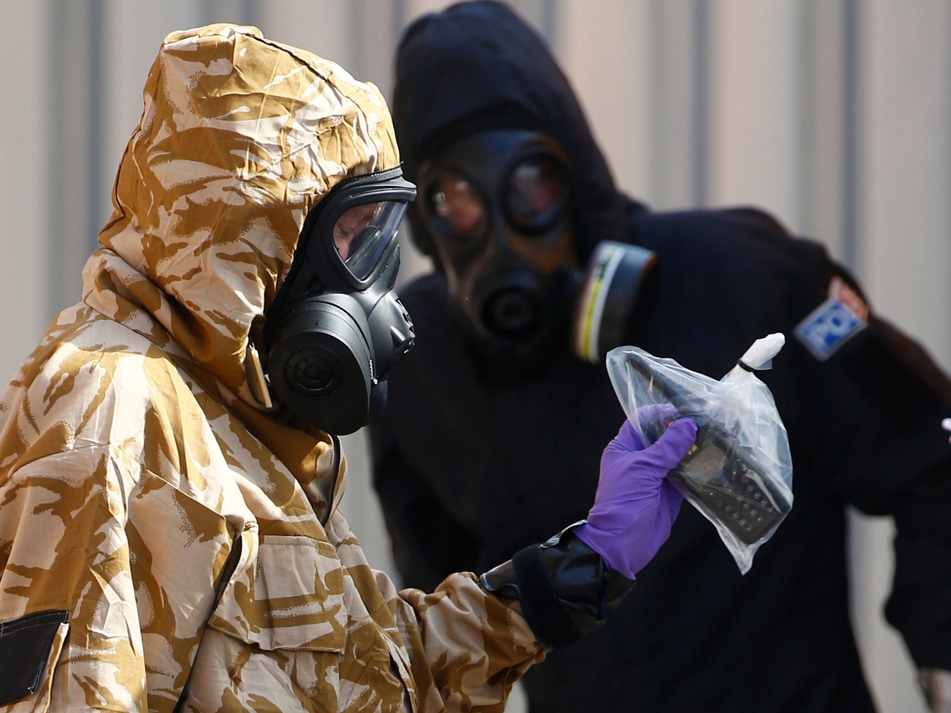 Forensic investigators, wearing protective suits, emerge with bagged evidence from the rear of John Baker House in Salisbury, after it was confirmed that two people living in Amesbury had been poisoned with the nerve-agent Novichok.