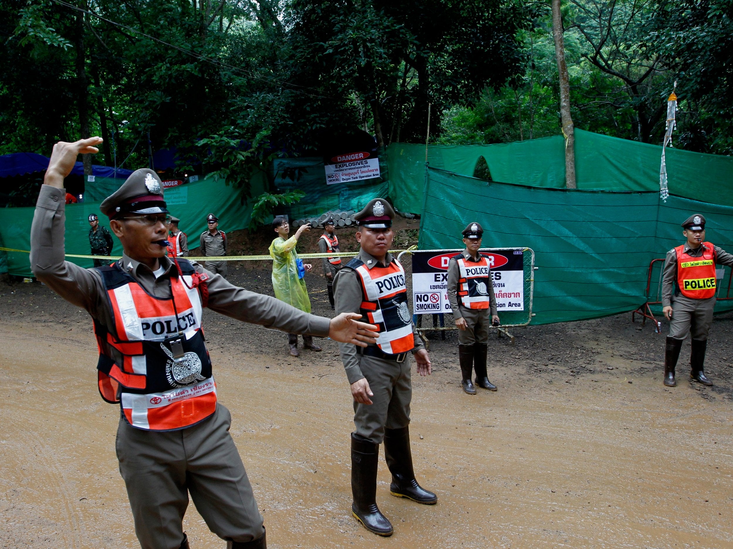 Thai police officers proceed on the traffic to clear the area in front of the cave during the 'D-Day' for the ongoing rescue operation