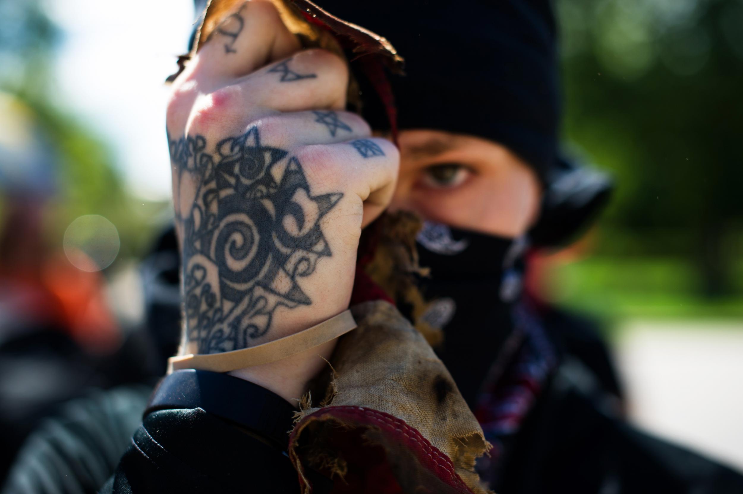 An Antifa demonstrator holds up the remains of a tattered and burned US national flag during the Denver March Against Sharia Law in Denver, Colorado