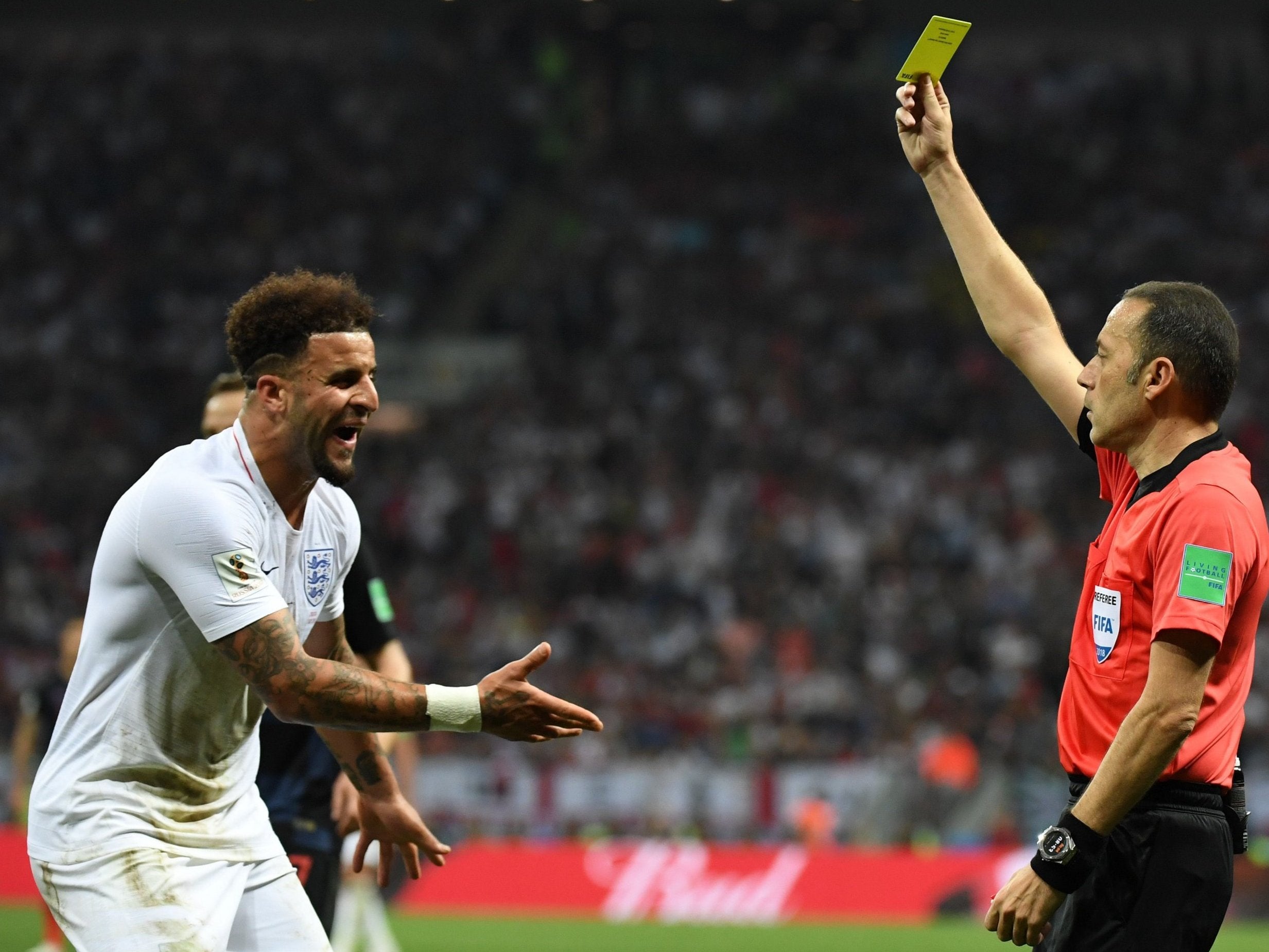 Kyle Walker is shown a yellow card by referee Cuneyt Cakir