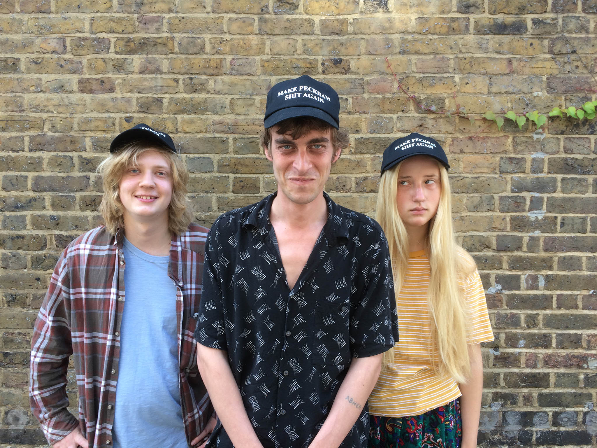 Saul from Peckham-based rockers Fat White Family (centre) wears a ‘Make Peckham Shit Again’ cap with siblings Sasha and Vida Adamczewski