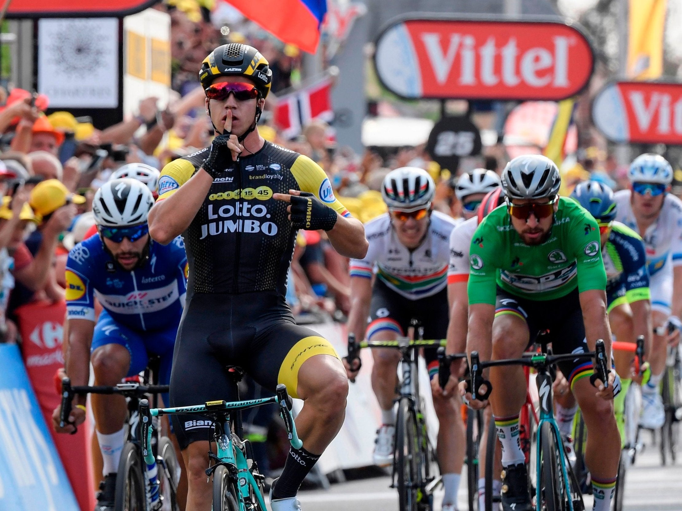 Dylan Groenewegen celebrates as Fernando Gaviria and Peter Sagan look on