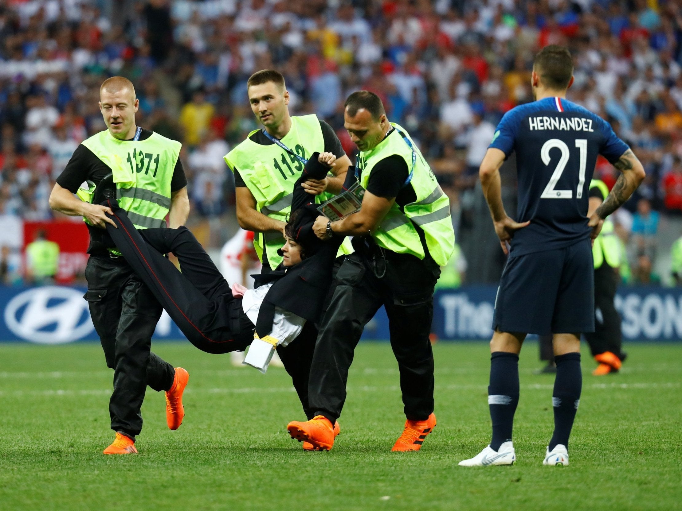 Stewards apprehend a pitch invader