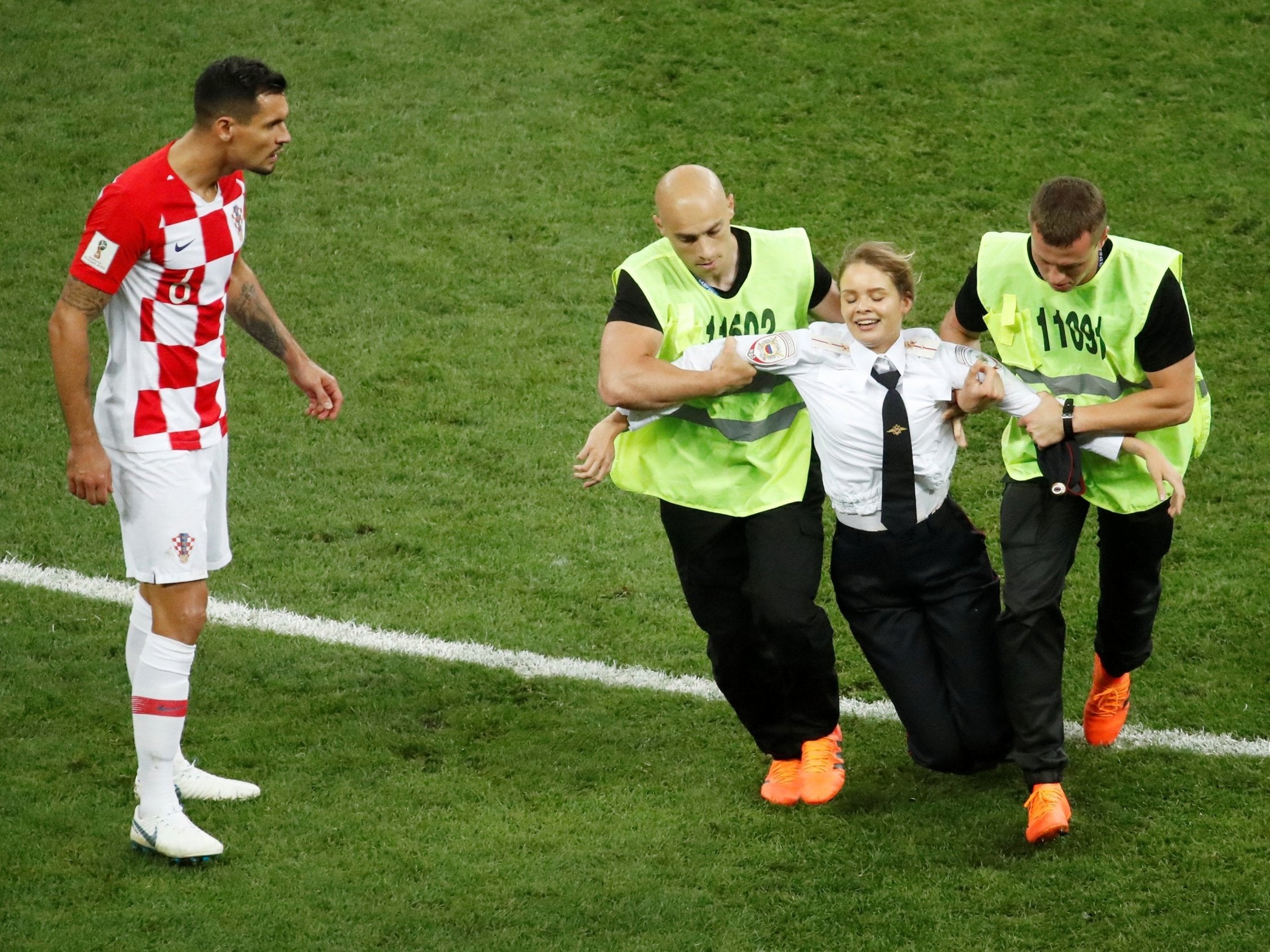 Stewards apprehend a pitch invader as Croatia's Dejan Lovren reacts