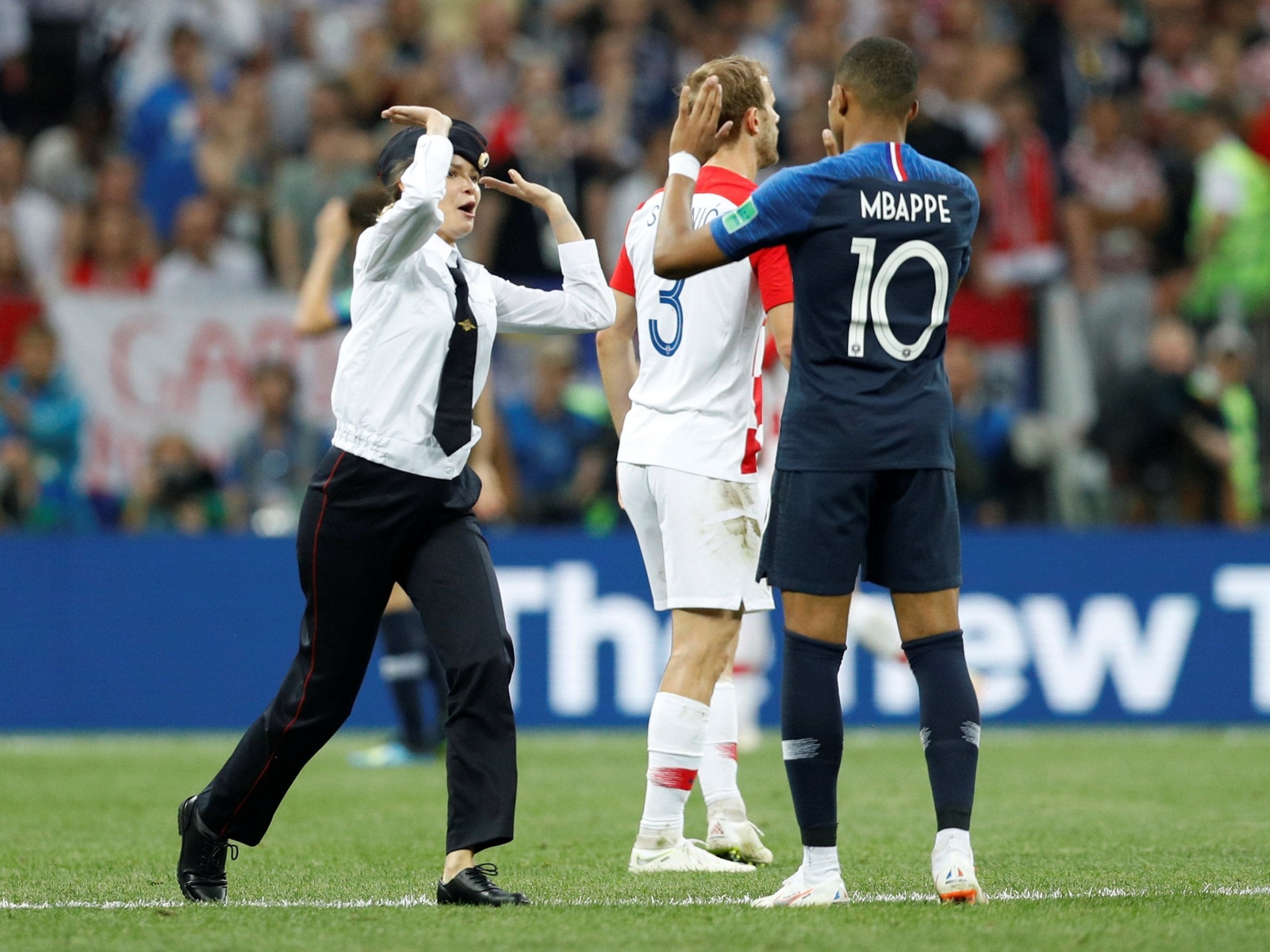 A pitch invader and France's Kylian Mbappe high five