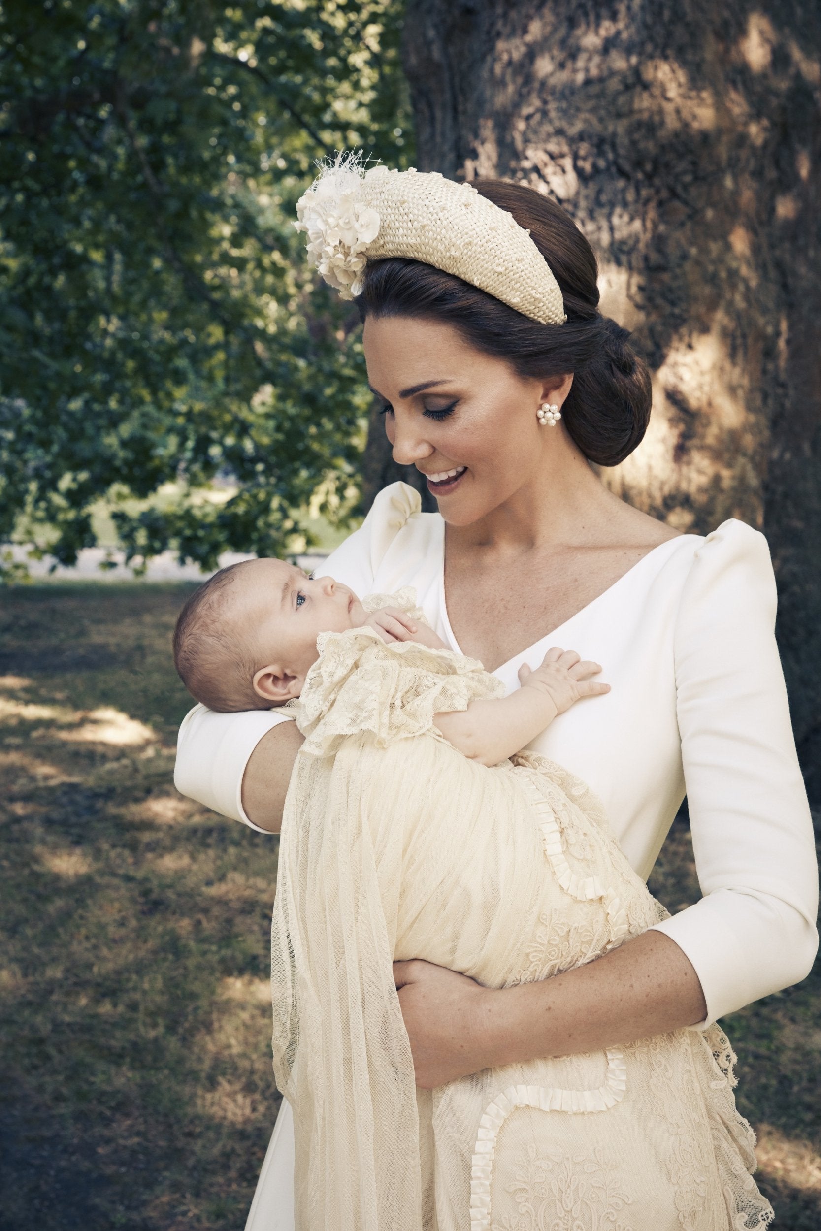 The Duchess of Cambridge holds Prince Louis in her arms on the grounds of Clarence House