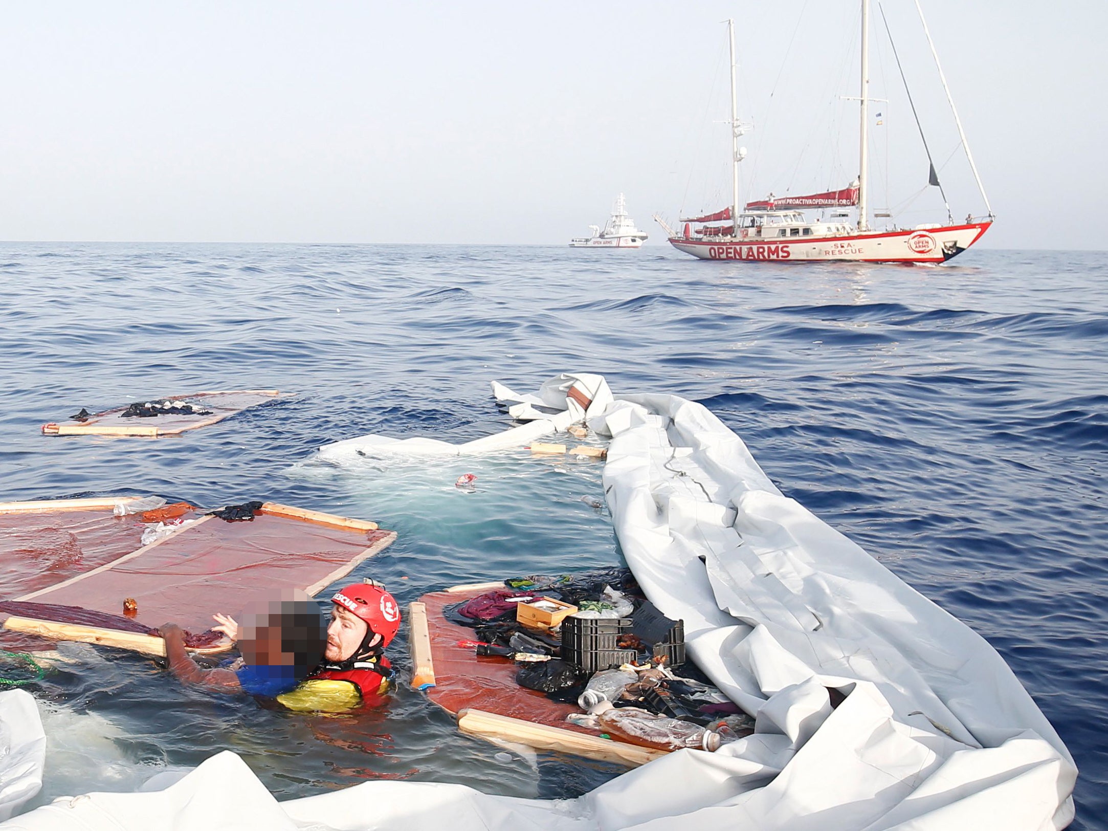 A member of the Spanish Proactiva Open Arms group rescues a woman who survived the sinking of a migrant boat