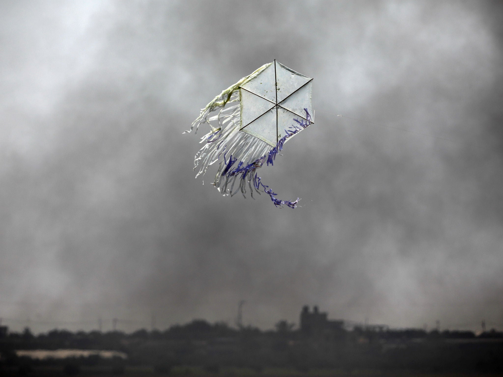 A kite flies over the border in an area where kites and balloons have caused blazes, between Israel and Gaza