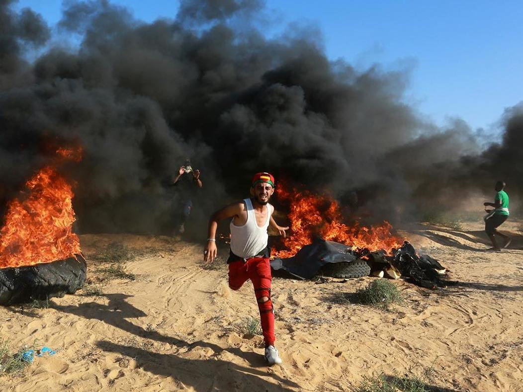 Protesters set tyres on fire as Israeli forces intervene to disperse demonstrators taking part in the Great March of Return