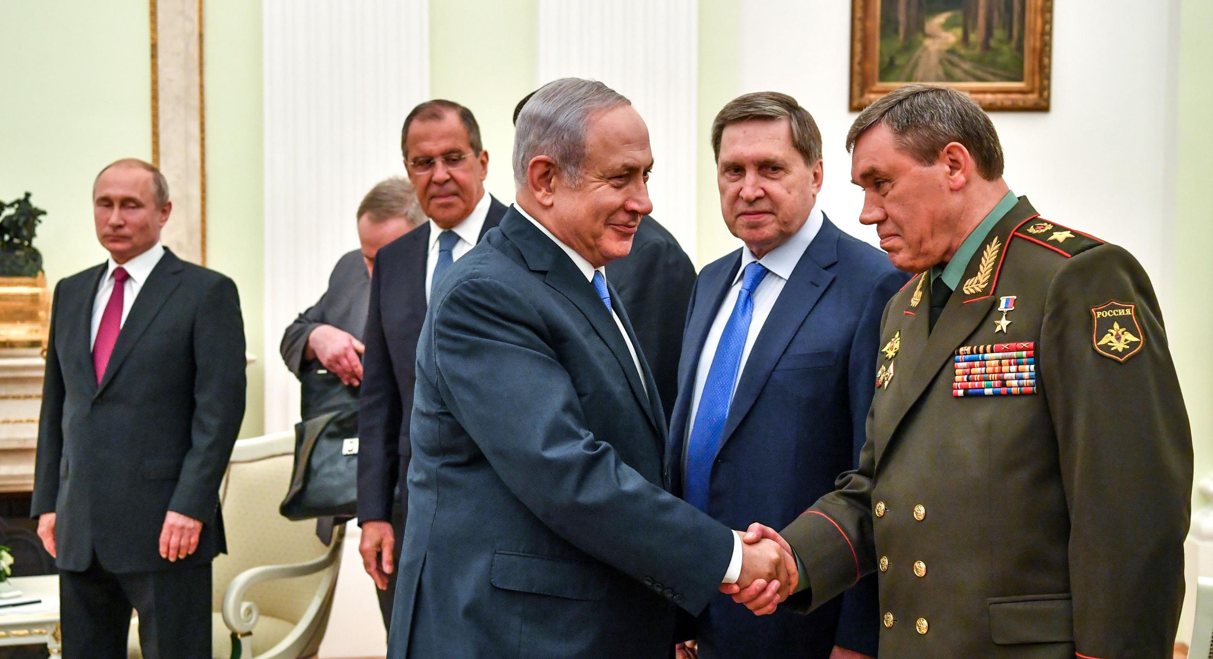 Valery Gerasimov, Russia's Head of the General Staff of the Armed Forces, shakes hands with Israeli Prime Minister Benjamin Netanyahu as Russian President Vladimir Putin looks on during their meeting at the Kremlin in Moscow on July 11, 2018