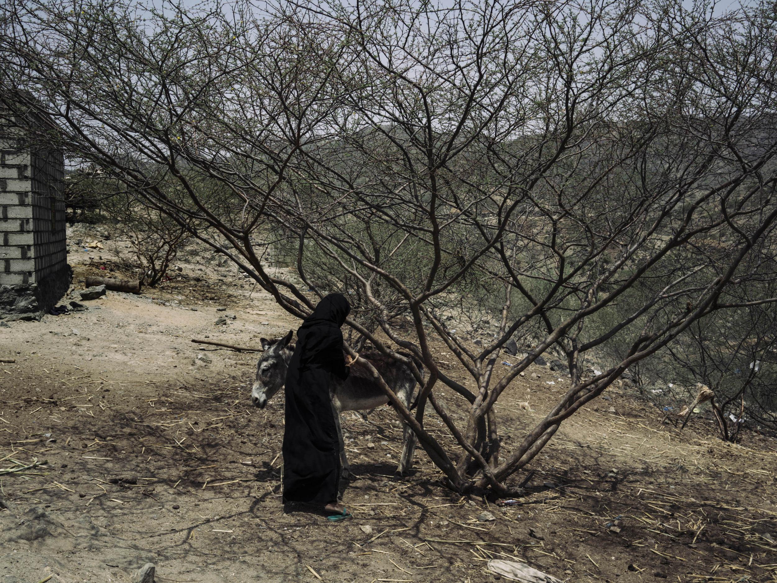 Amna Yahya, the mother of the groom, works near the shack where her son now lives with his wife