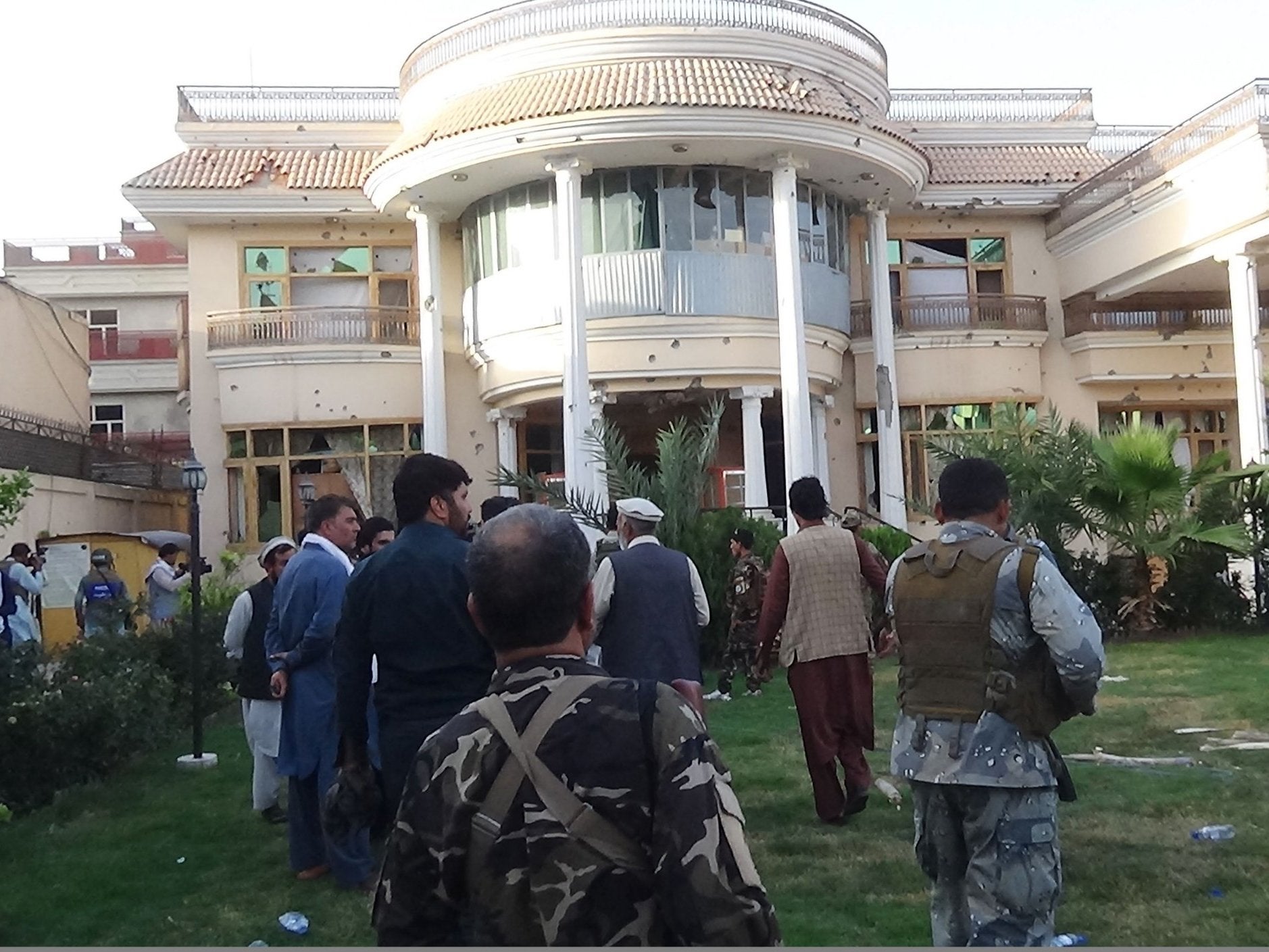 Afghan security forces inspect the damage after the attack on the midwife training centre