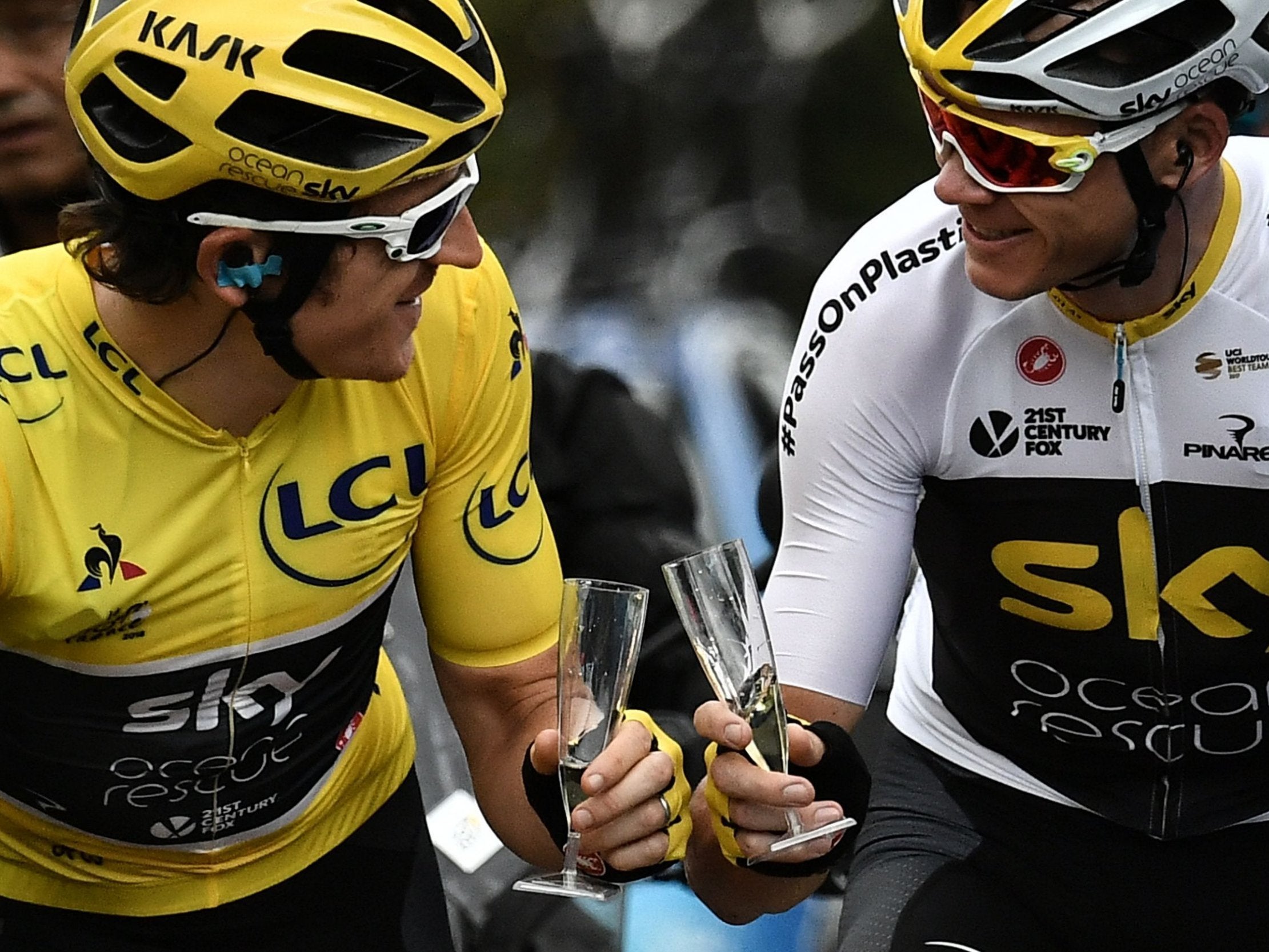 Geraint Thomas and Chris Froome clink glasses on the road