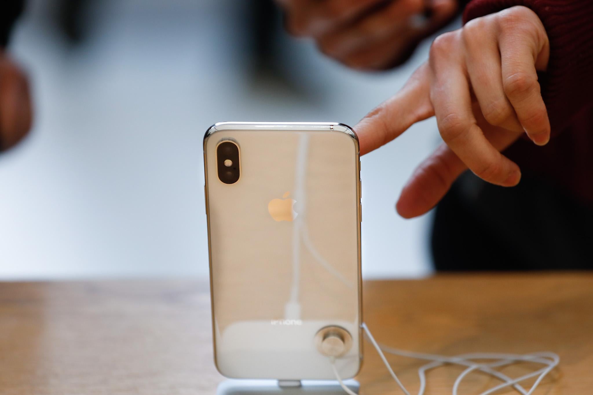 A customer touches the screen of the new iPhone X at the Apple Store Union Square on November 3, 2017, in San Francisco, California